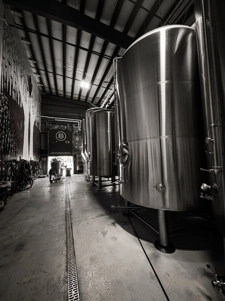 A mural-lined aisle between stainless tanks at Burlington Beer Co.’s Williston brewery. Archive photograph.