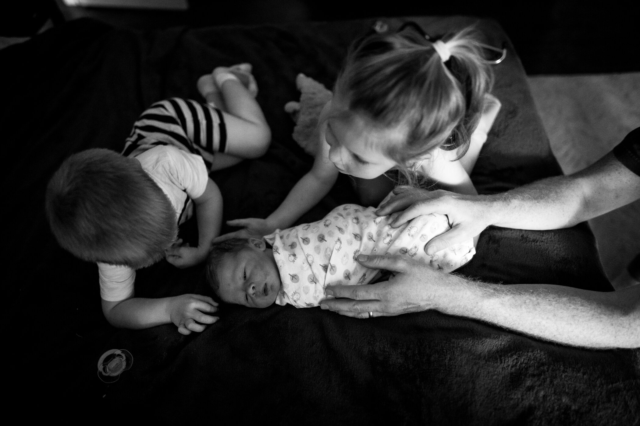 Older siblings love on their newest brother after he was born safely at home in Northern Virginia