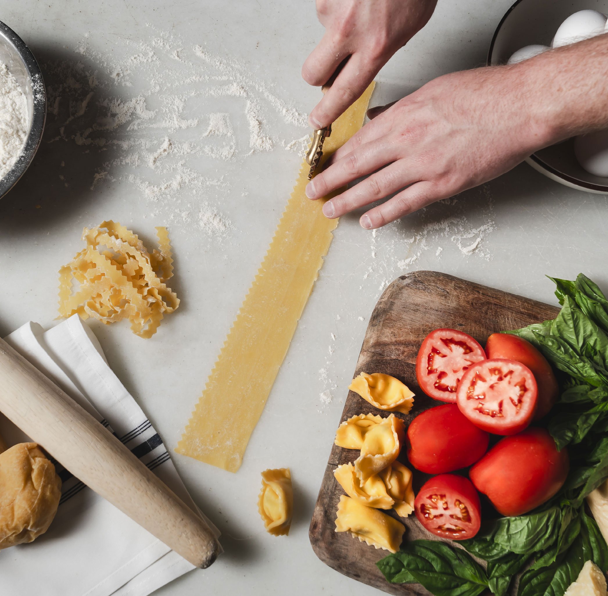 person cutting fresh pasta