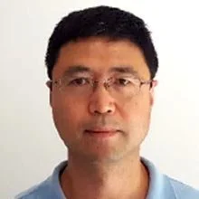 Portrait of a man wearing glasses and a light blue collared shirt.