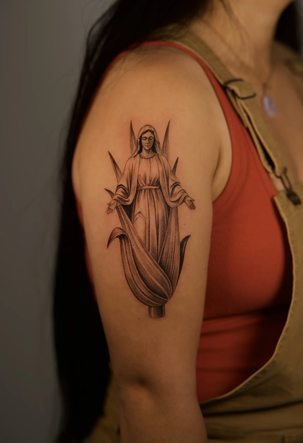 Fine line black and grey Virgin Mary tattoo in realistic microrealism style, inspired by corn imagery, tattooed on the upper arm by Brian Parrillo at Ethereal Tattoo Gallery in Durham, North Carolina.