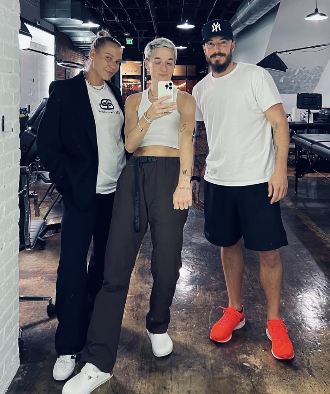 Tattoo artist Brian Parrillo with professional soccer players Megan Rapinoe and Merritt Mathias at Ethereal Tattoo Gallery in Durham NC