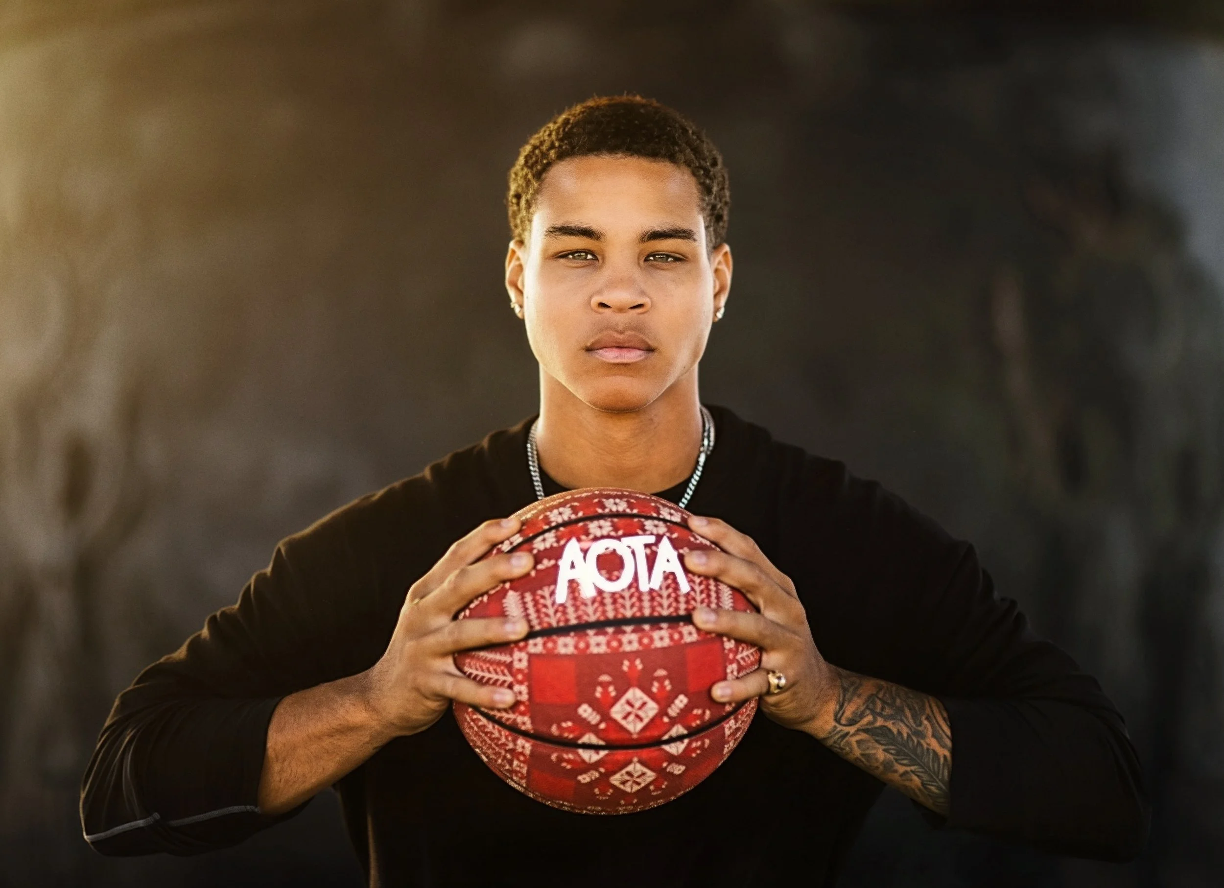 Young person holding a decorated Christmas-themed ball, looking directly at the camera with a serious expression.