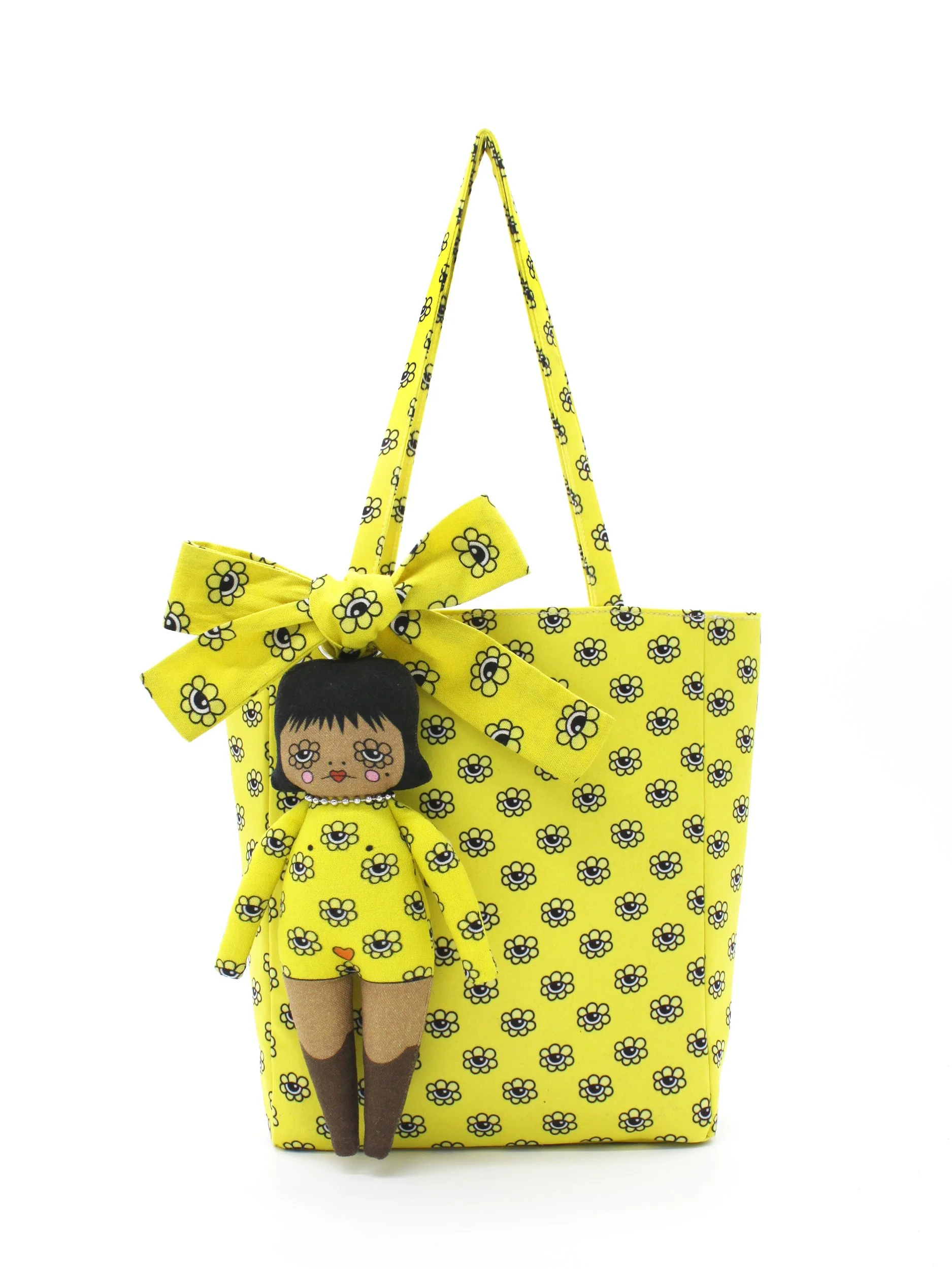 The Bri Foster Dolls yellow mini tote bag shown with a medium-skinned art doll charm accessory featuring a chic black hairstyle.