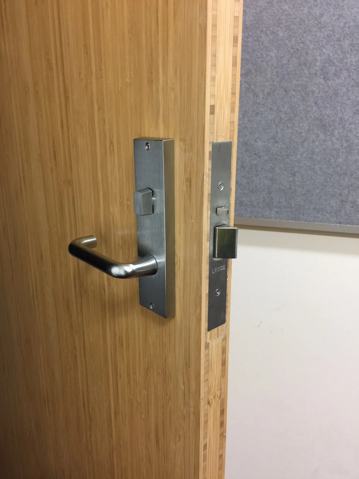 Close-up of a wooden door with metal hardware and a keypad lock.