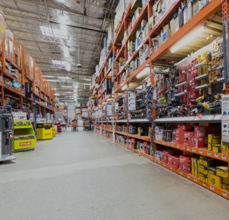 Aisle in a hardware store with shelves stocked with tools, equipment, and supplies.