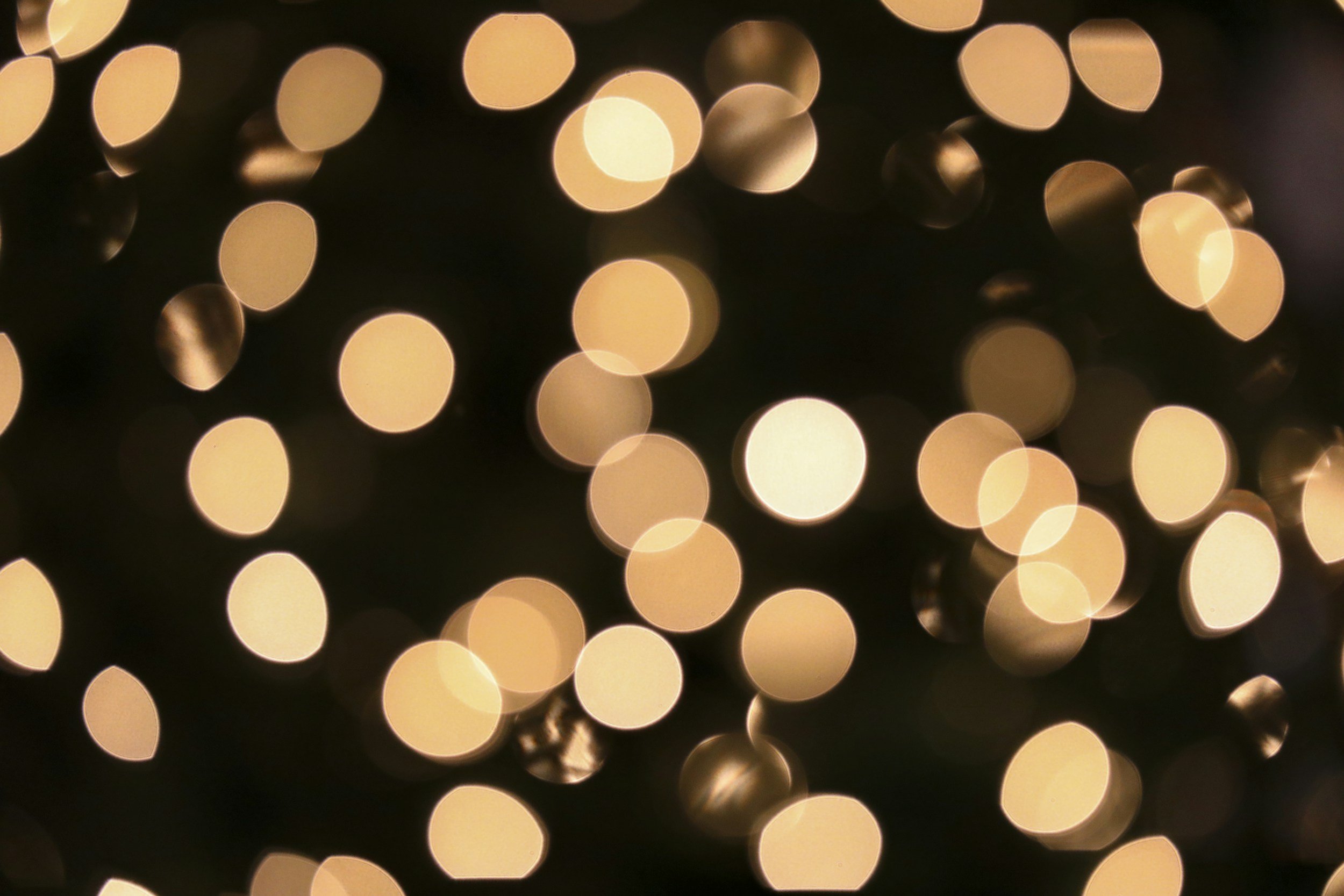 Blurred golden bokeh lights against a dark background.