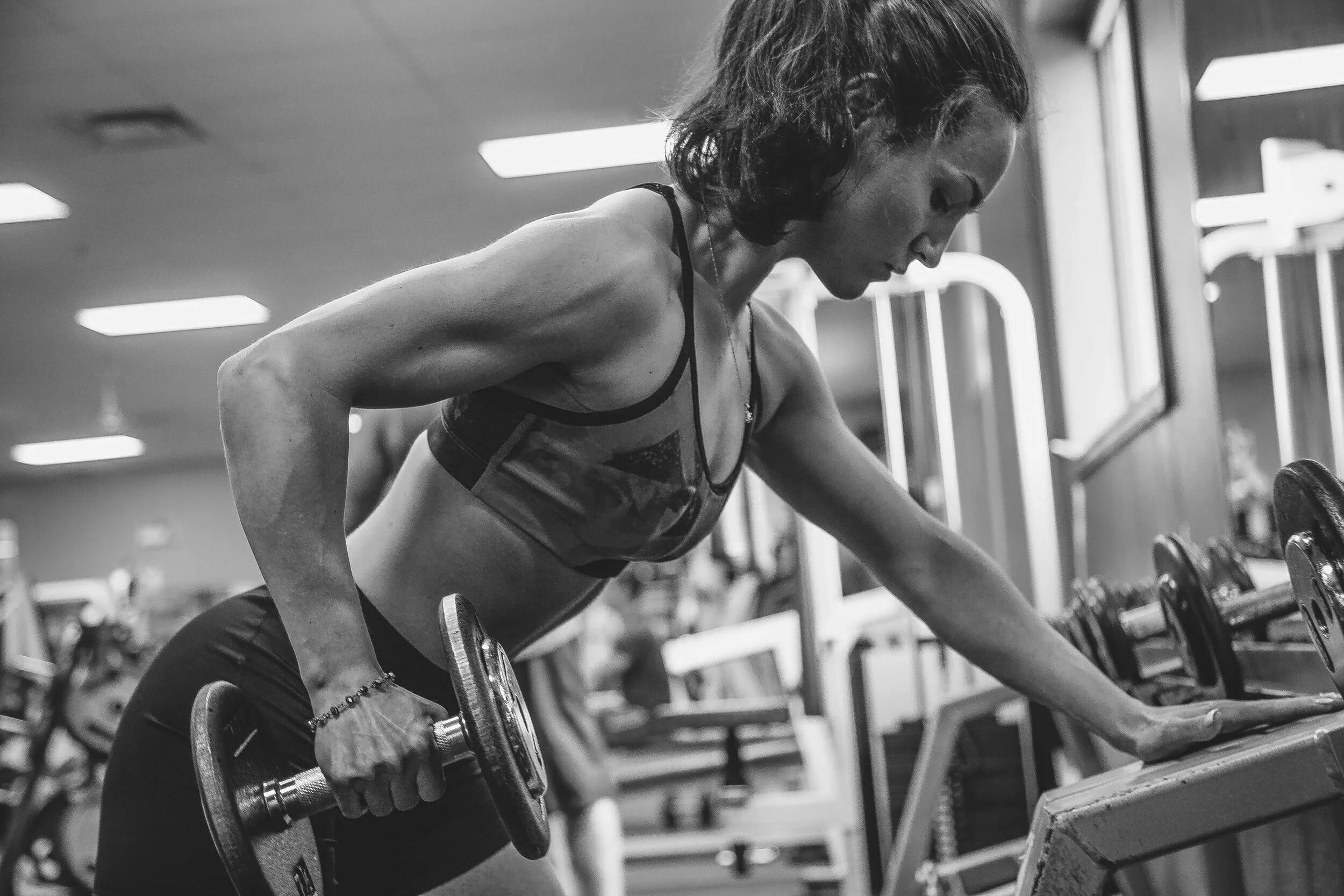 Women lifting weights during a workout in a gym.