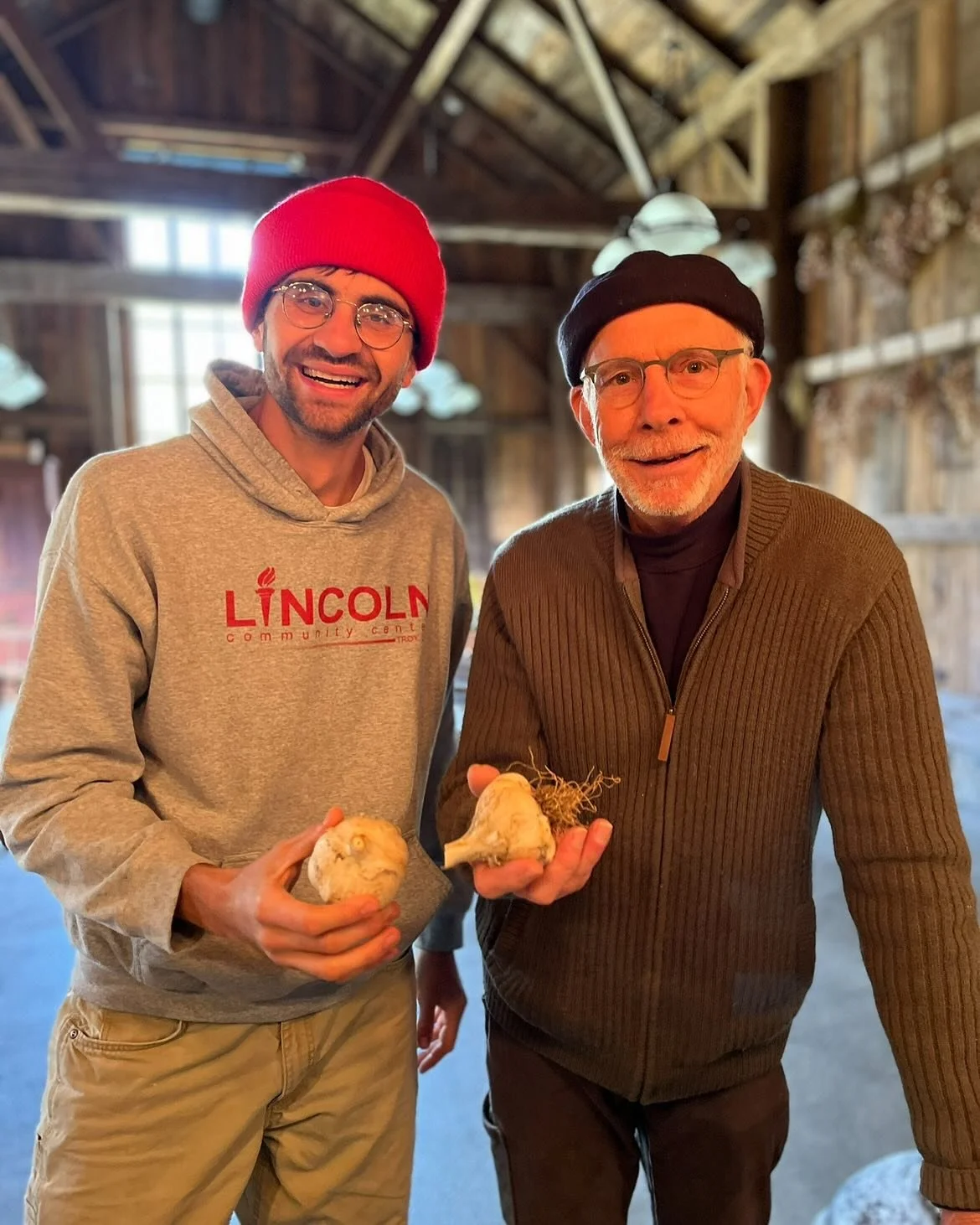 Friendship looks like . . . John, a Stonewood volunteer and friend, and Lex, our Farm Manager, side by side. Pictured here, they are holding part of John&rsquo;s harvest of Hryshko Legacy, a Ukrainian hardneck garlic that John has lovingly cultivated