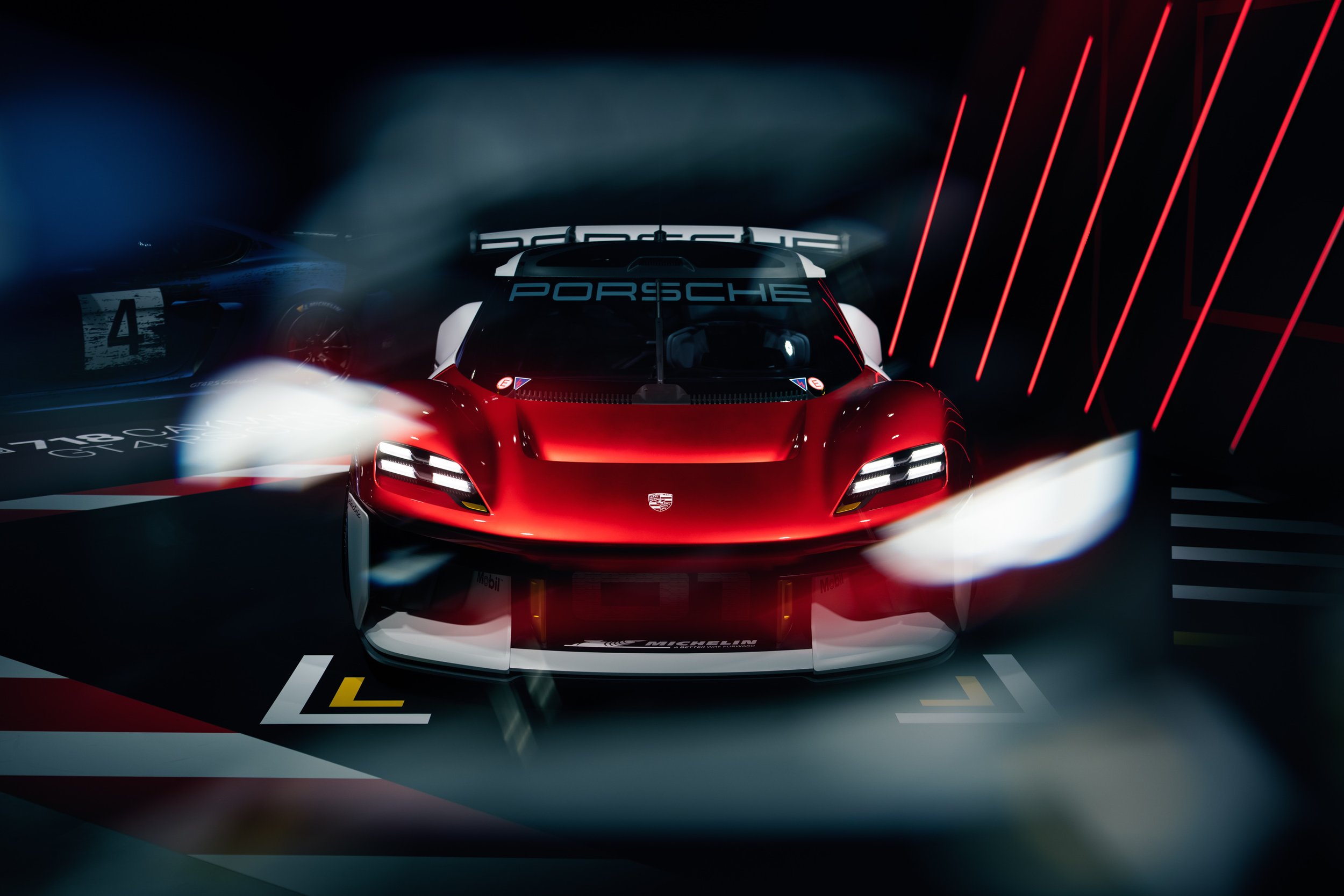 Red sports car with illuminated headlights in a dark showroom featuring red accent lighting, showcasing Porsche branding.