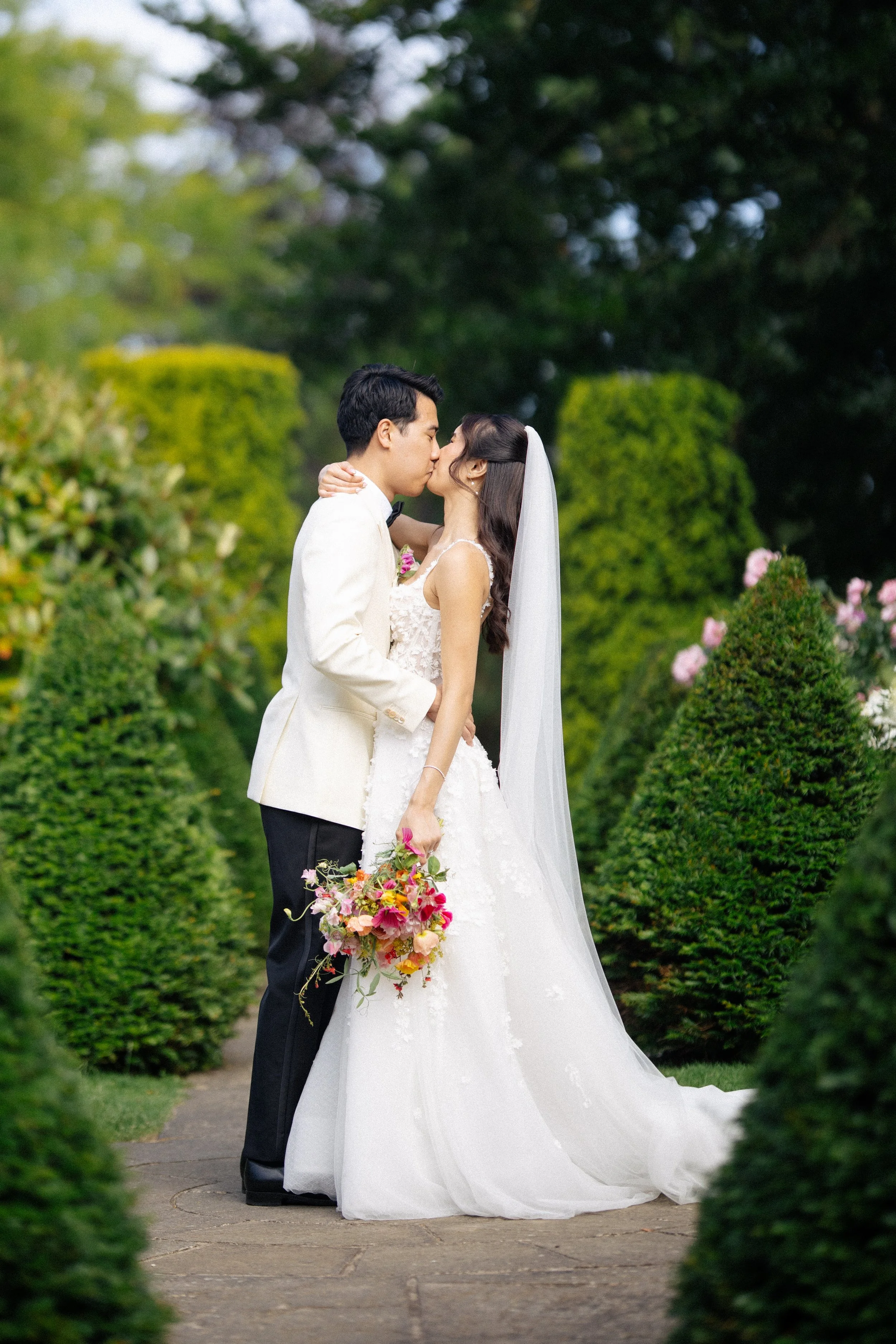 A bride and groom kiss in the beautiful gardens at the Orangery, Maidstone