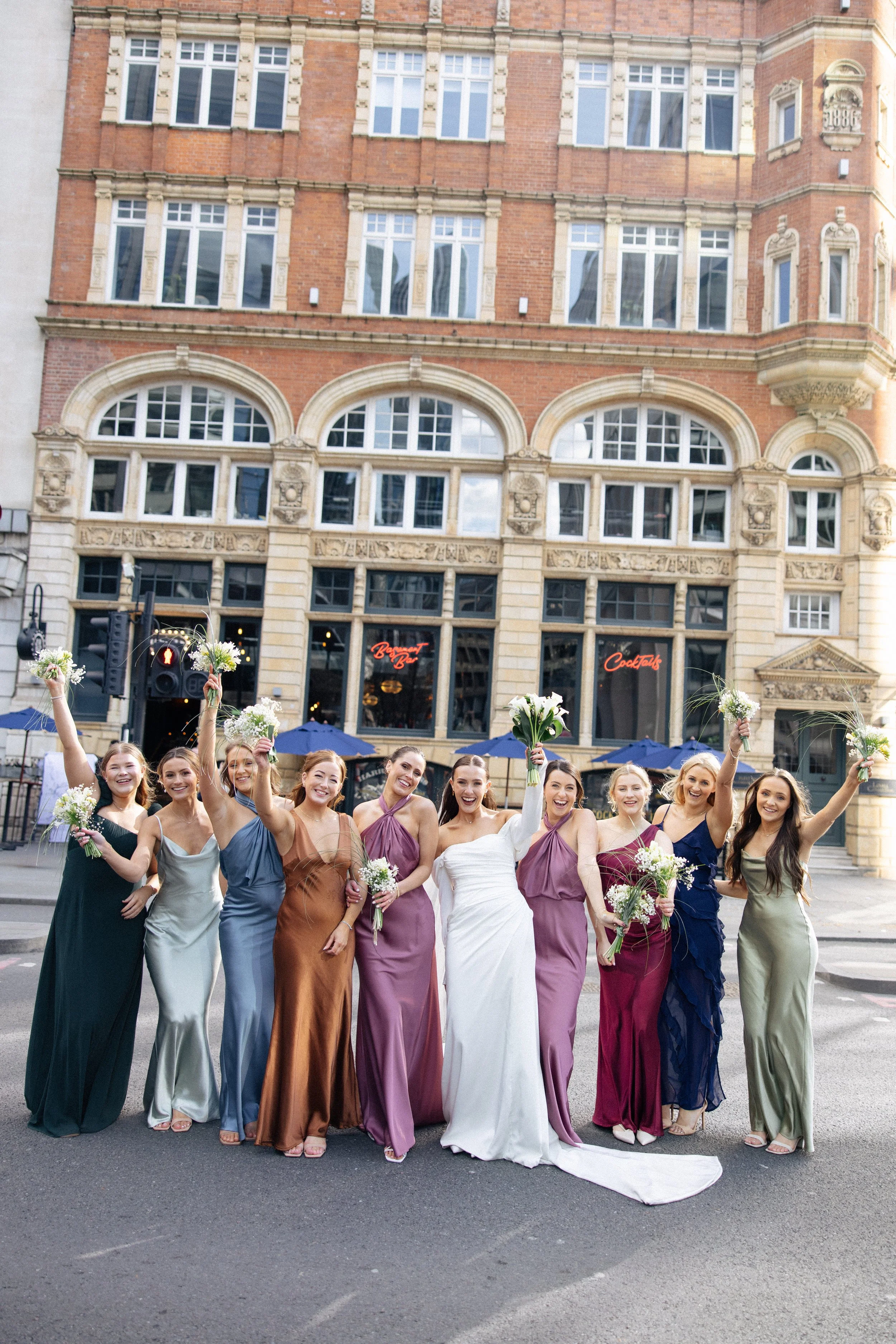 The wedding bridal party pose and cheer outside Harrild and Sons