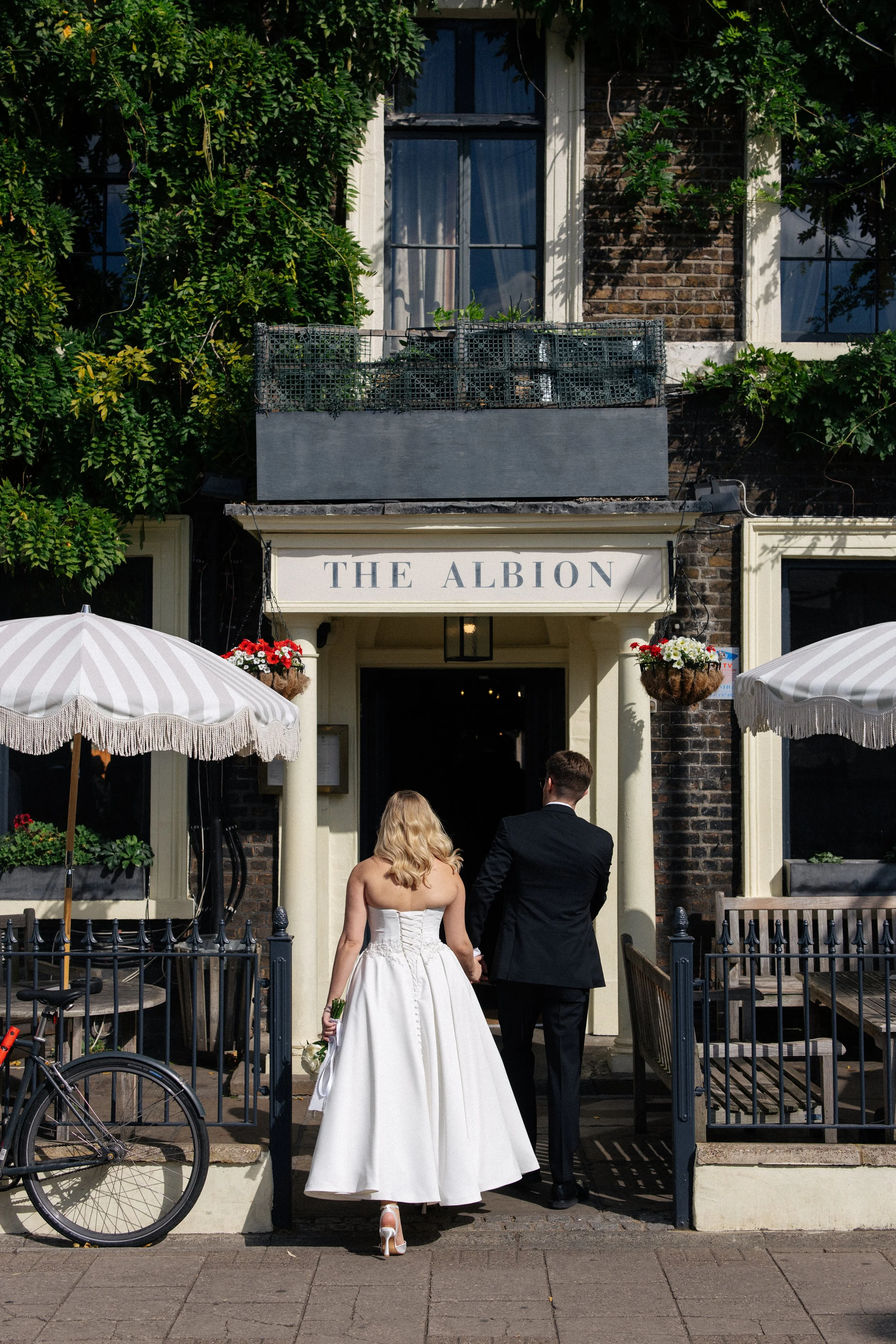 A bride and groom walk into the Albion Pub in Islington