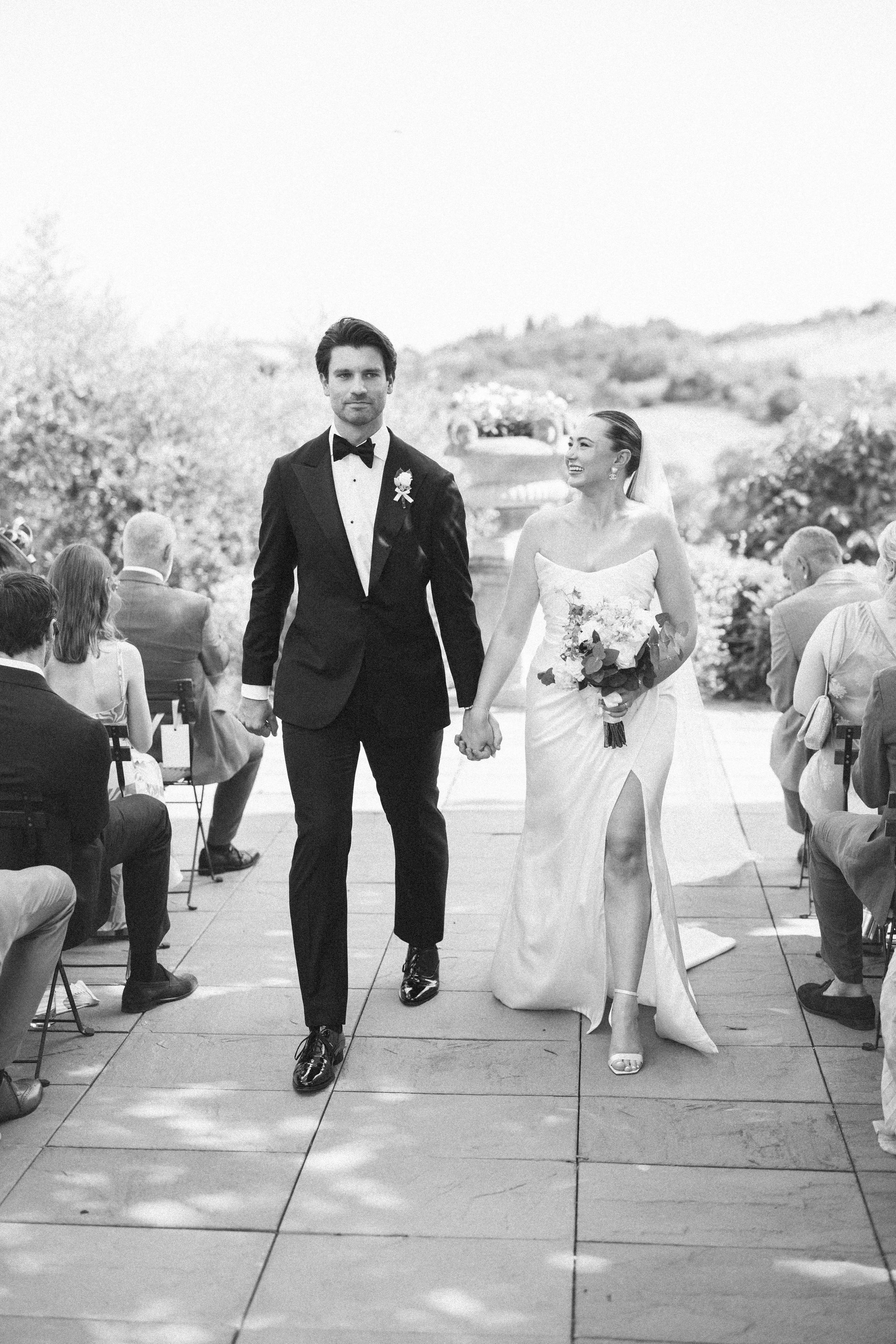 A bride and groom walk up the aisle after their wedding ceremony at Tenuta Corbinaia in Tuscany