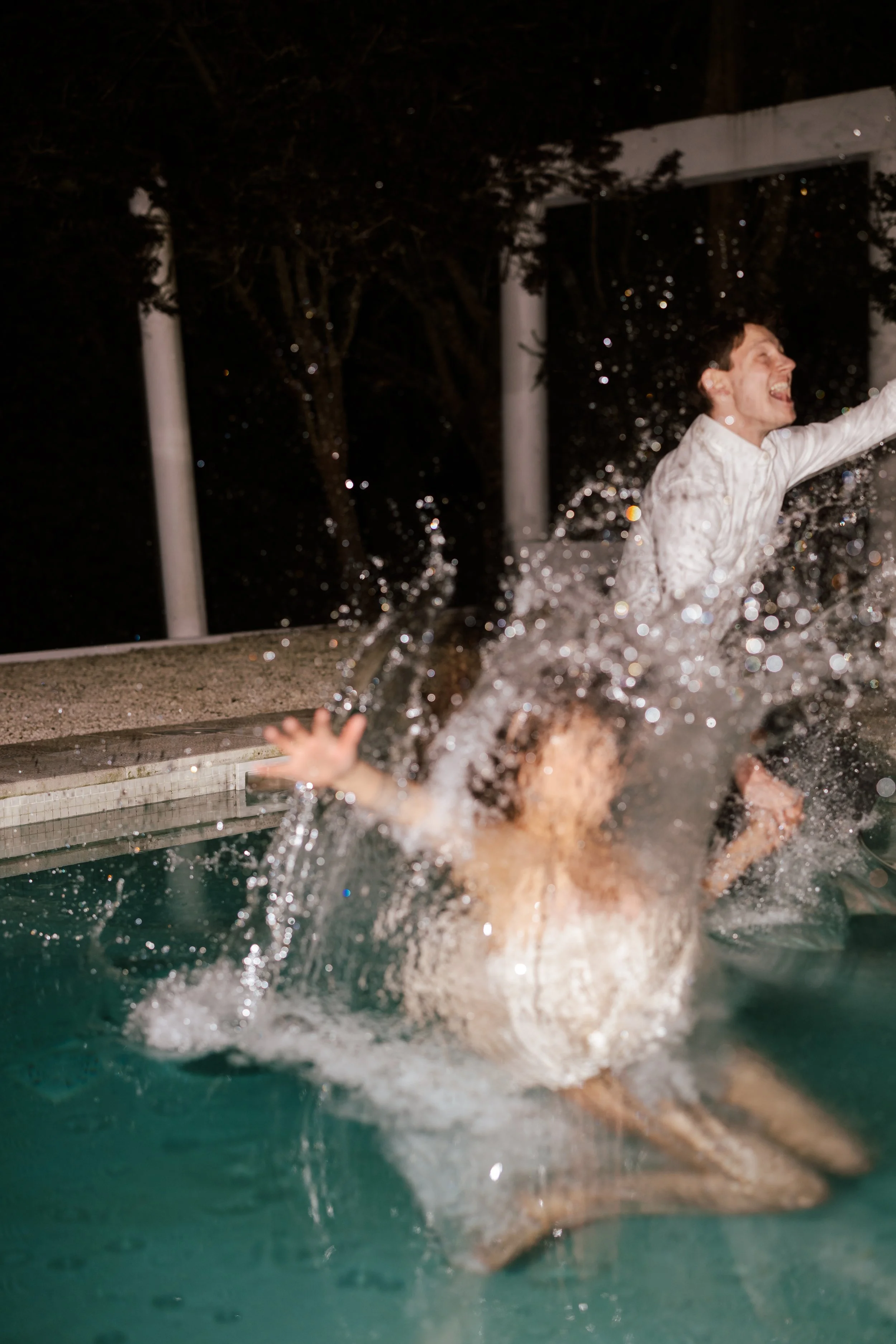 A bride and groom jump into the swimming pool after their wedding at Casa Sacoto in Spain