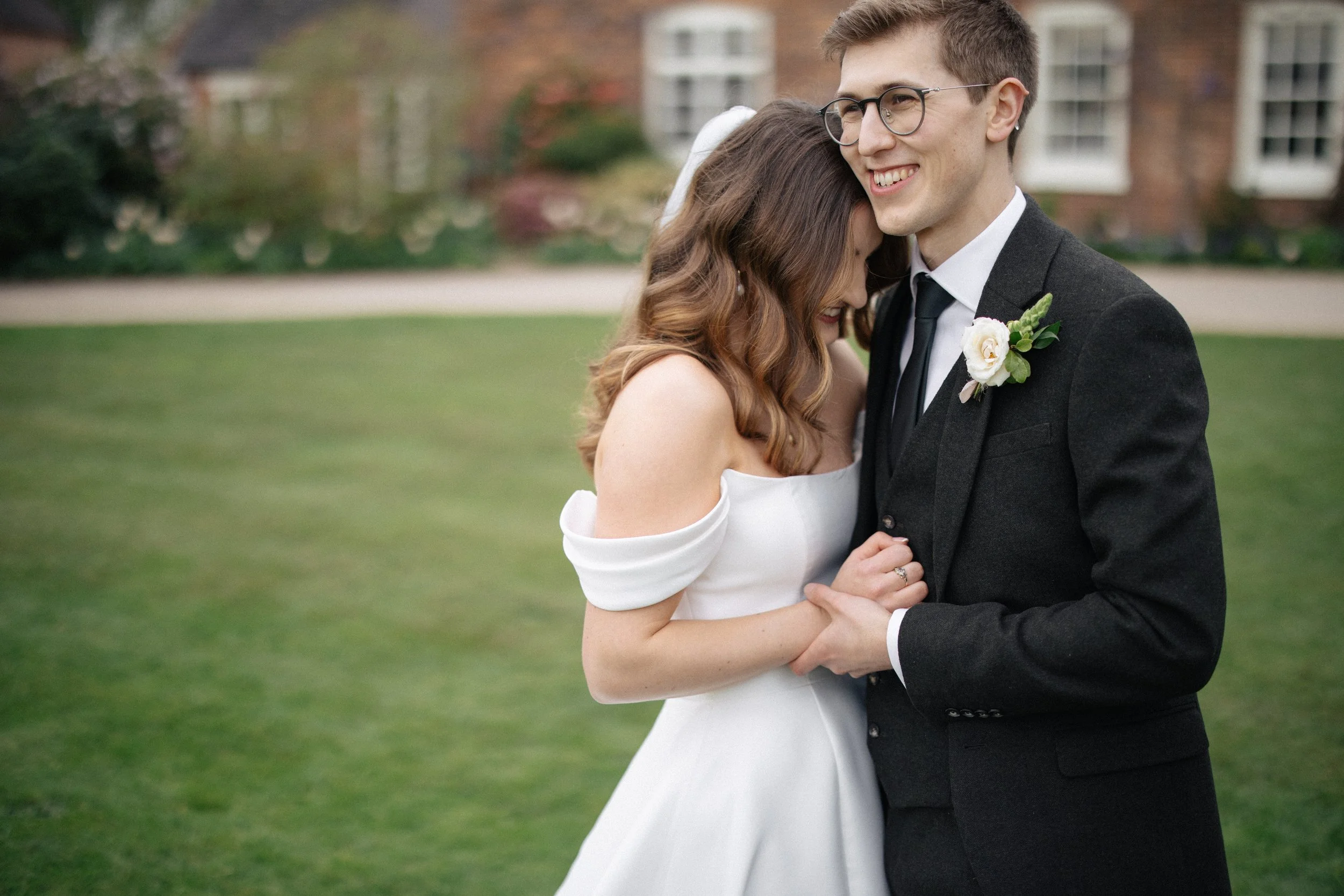 A candid photo as the couple embraces before their photos at their wedding at Alrewas Hayes