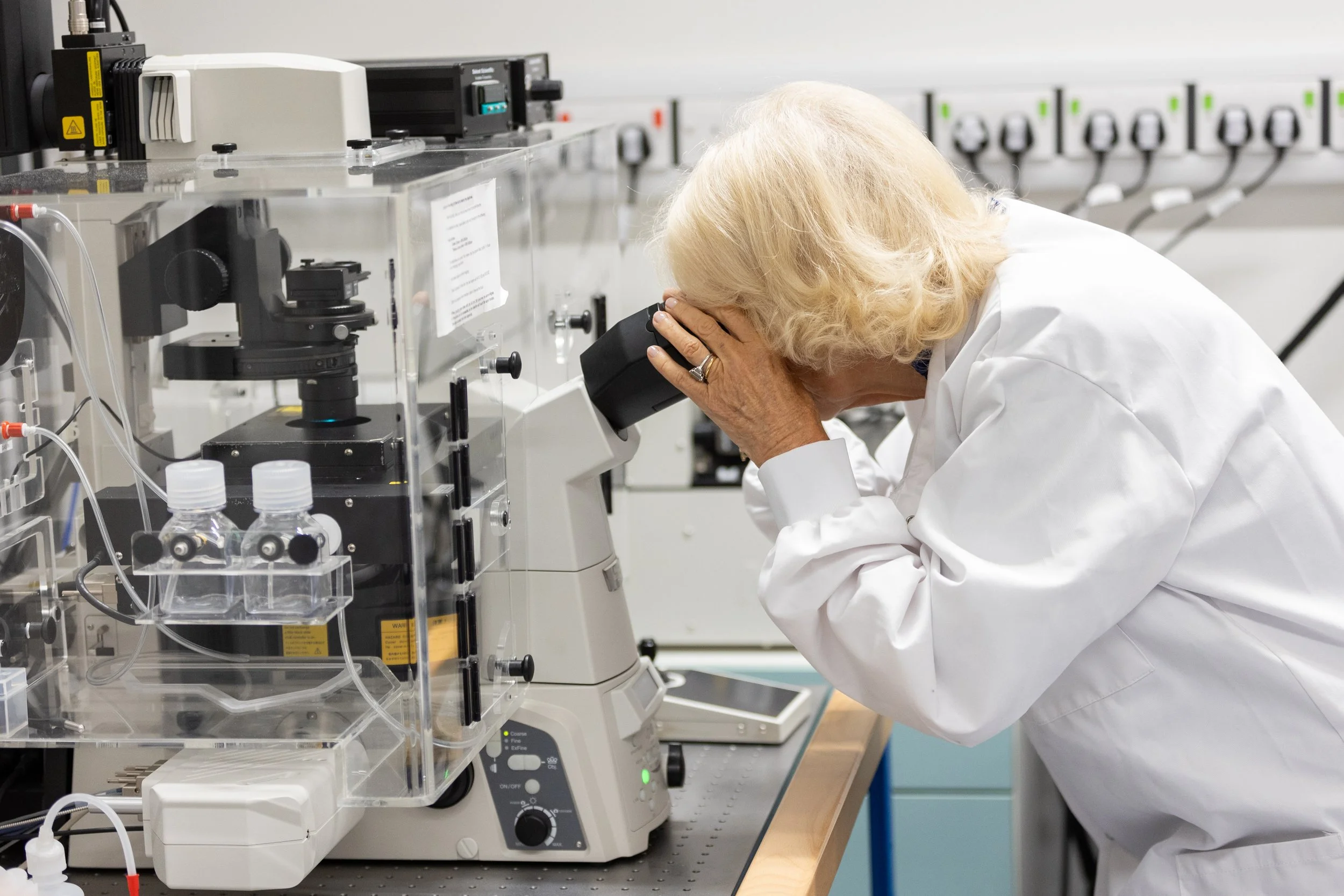 Queen Camilla looks through a telescope while on a visit to a JDRF research project.