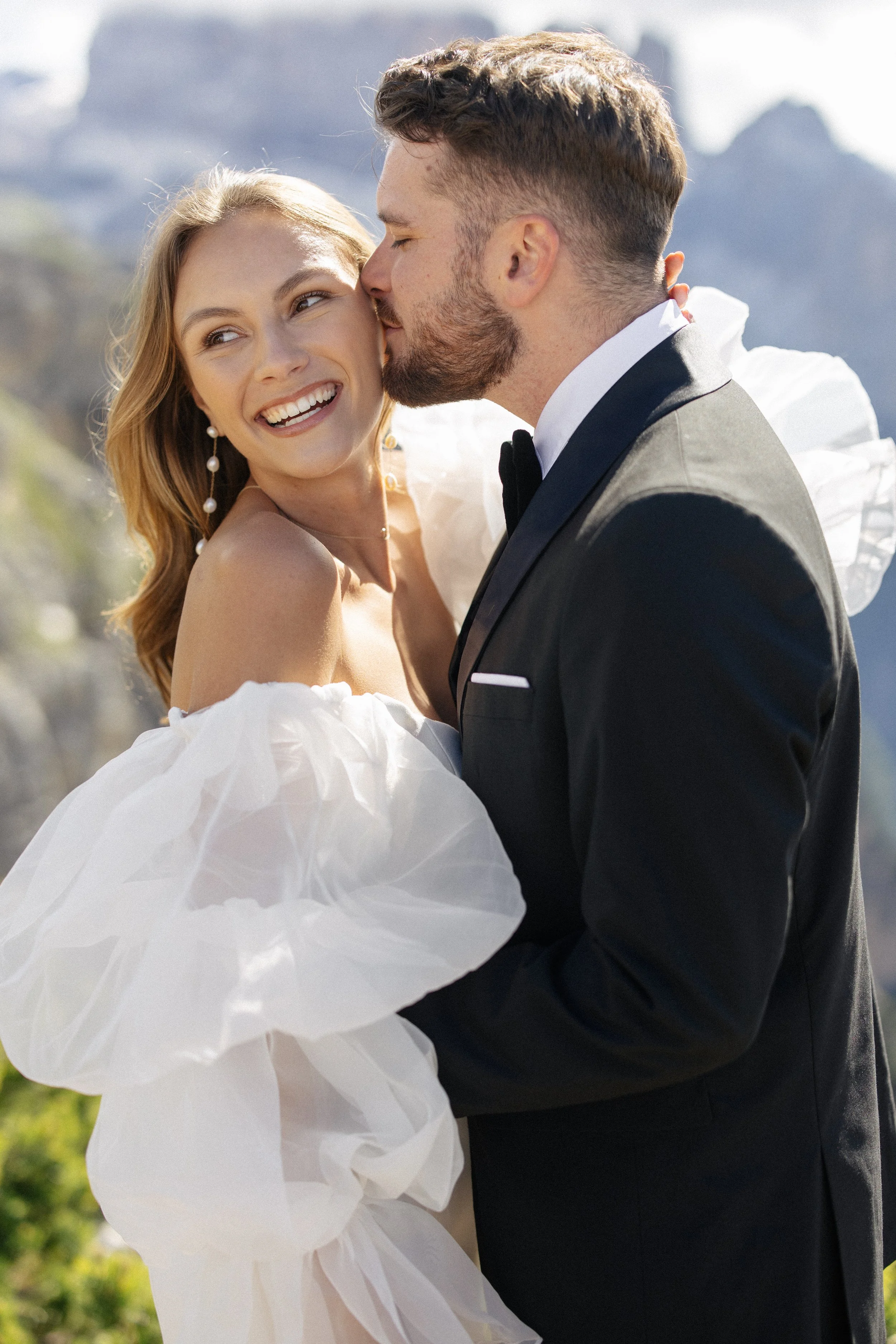 A groom kisses his bride during their elopement in the Dolomites in Italy