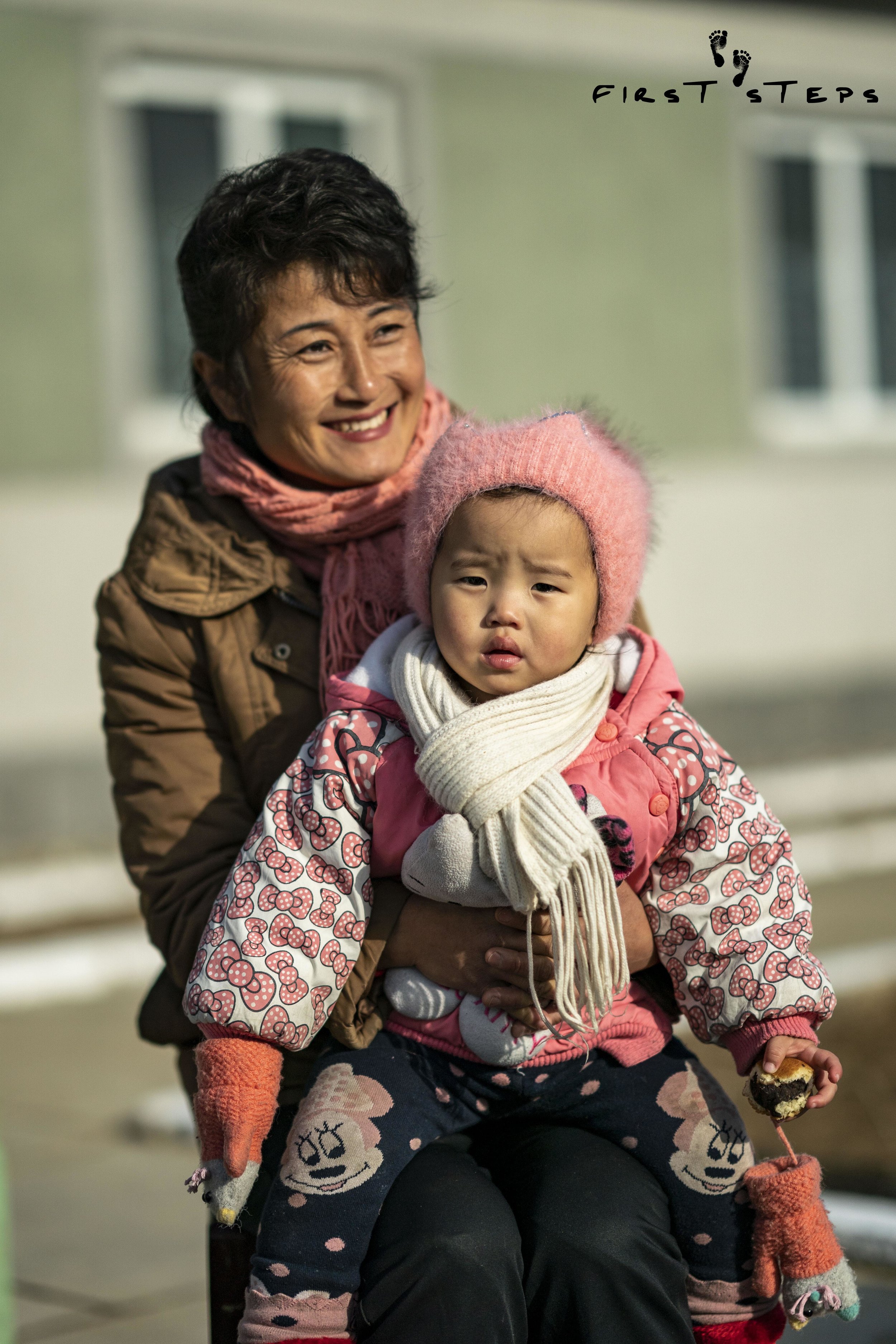 Mrs. O Mi-Yang and her one-year-old daughter Bok-Ryon outside the Shinmi Policlinic. 