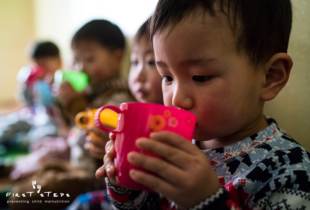 Careful sips of warm nutritious soymilk at the Yangji Daycare in Wonsan, Kangwon Province