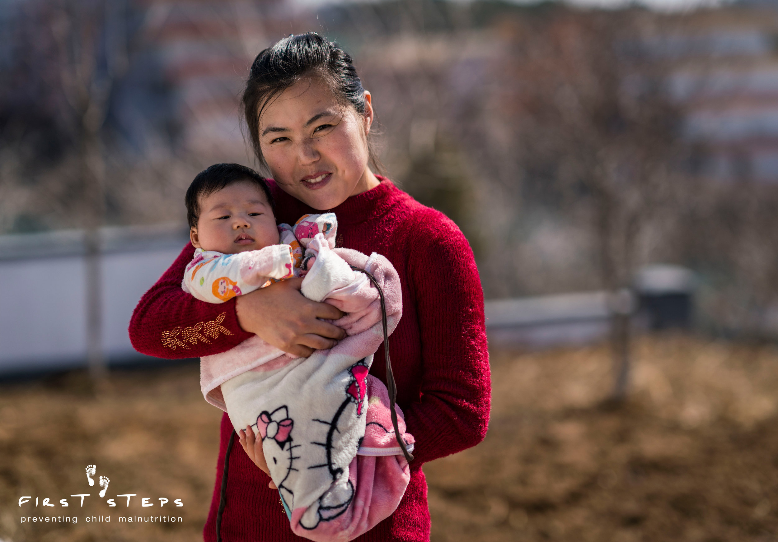 Choe Yun-Mi stands with her two-month-old son Kim Ui-Ryong.