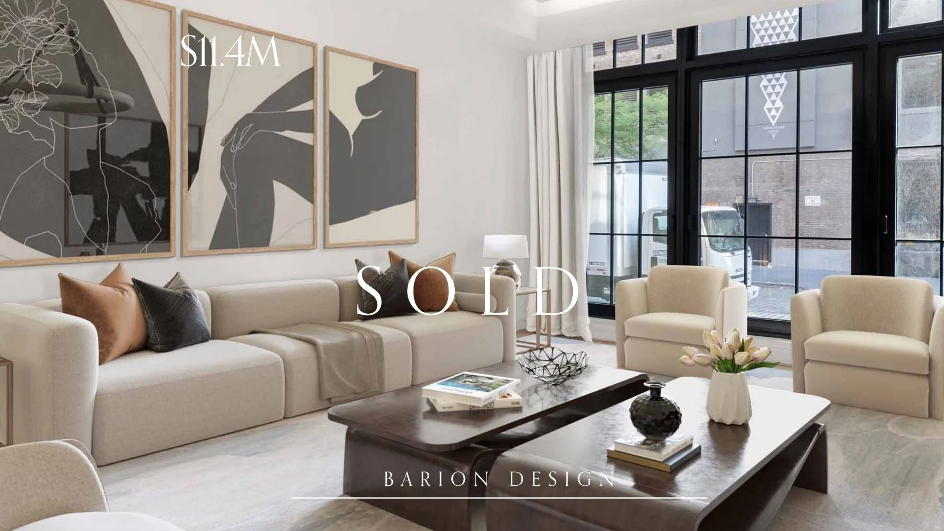Modern living room with beige sofa, armchairs, coffee table with decorative items, large black-framed windows, and minimalist wall art