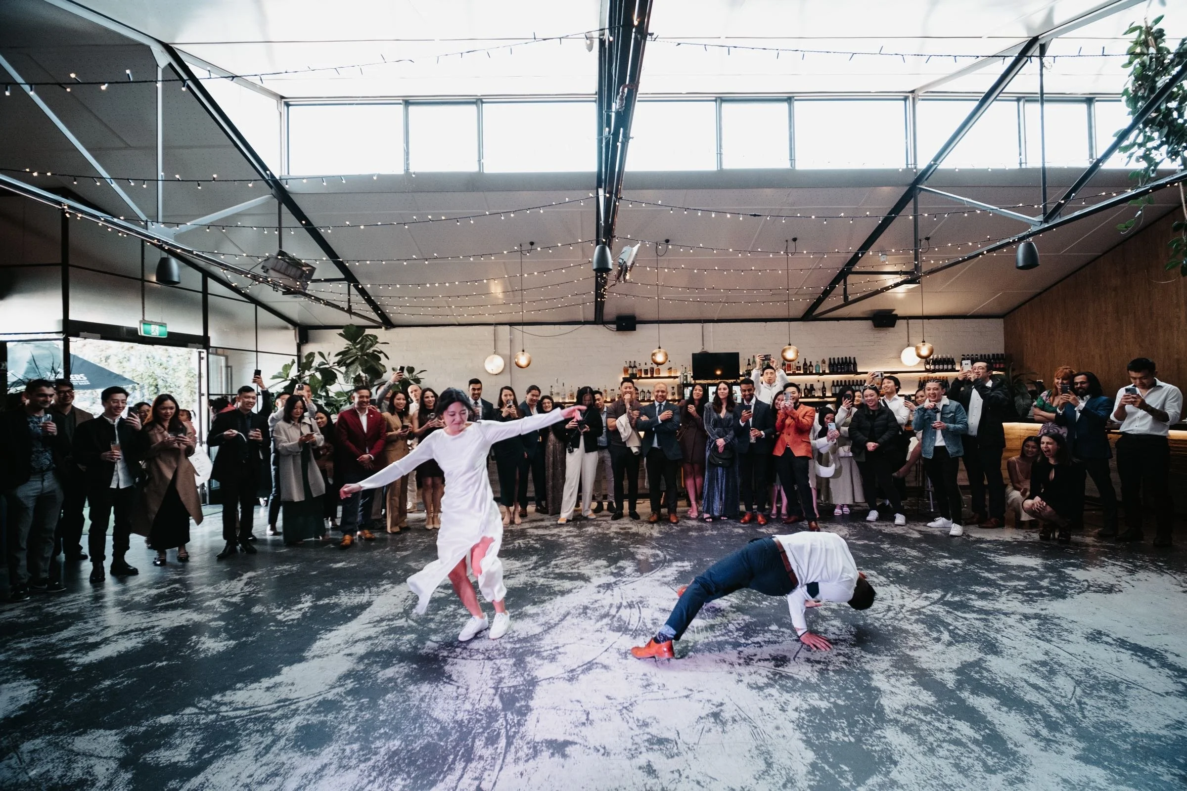 LUCY AND LYNX DANCING ON THE DANCE FLOOR SURROUNDED BY THEIR GUESTS, DOING A FREE STYLE FIRST WEDDING DANCE