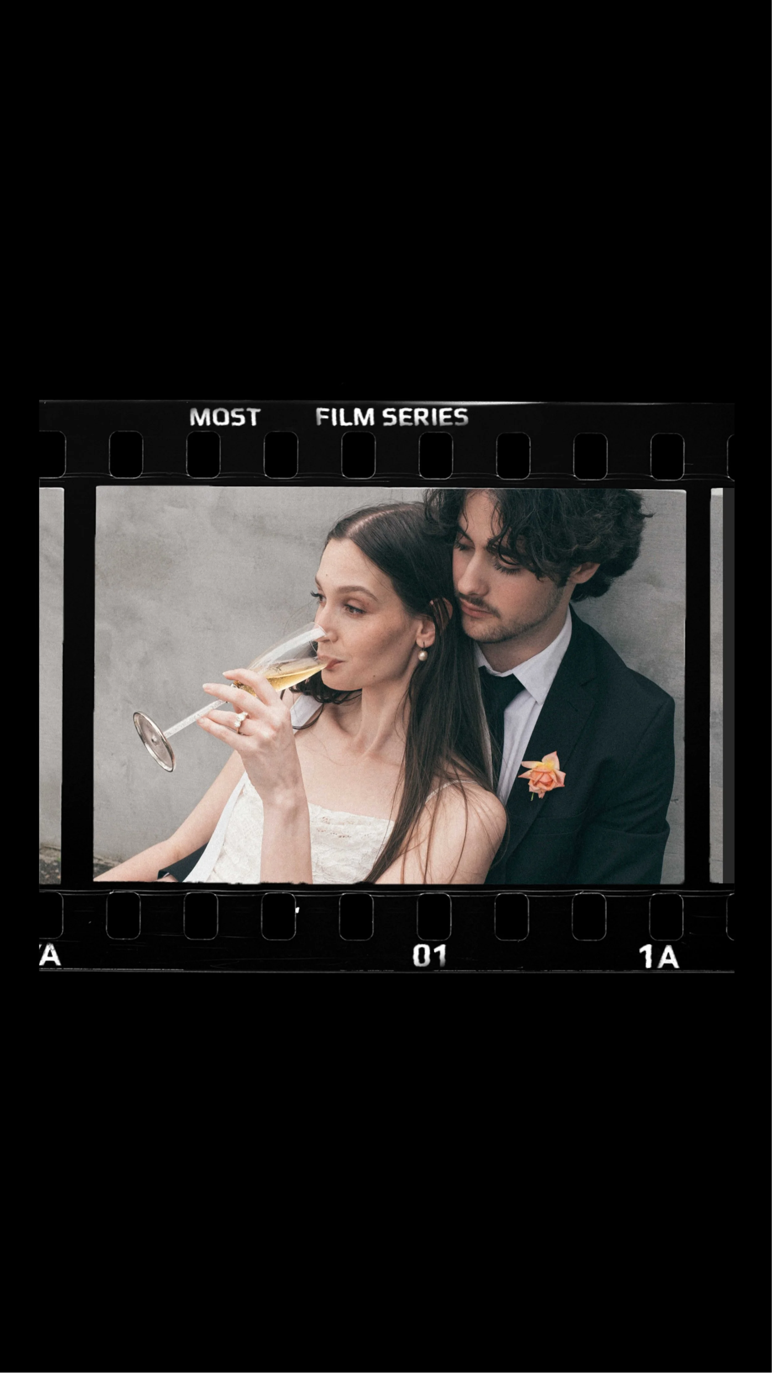 IMAGE OF A BRIDE HAVING CHAMPAGNE NEXT TO THE GROOM SITTING ON THE GROUND, AN INTIMATE IMAGE