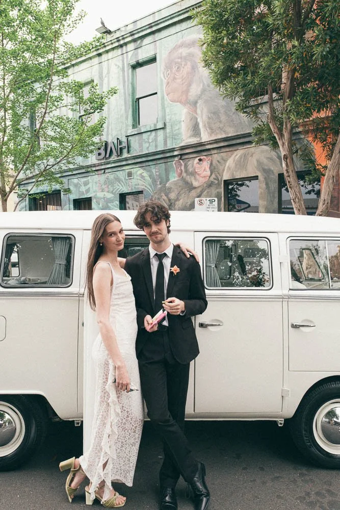 MELBOURNE  EDITORIAL WEDDING PHOTOGRAPHY, BRIDE AND GROOM POSING NEXT TO A OLD SCHOOL VW KOMBI VAN IN FRONT OF HUGE GRAFITTI