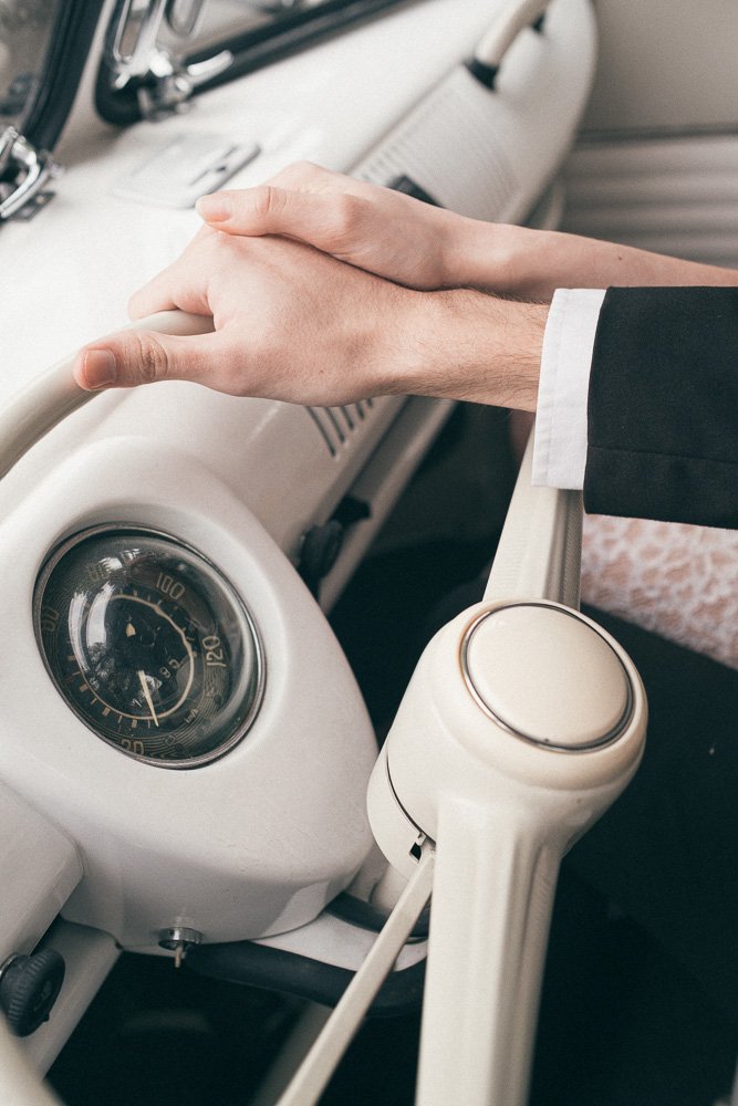 MELBOURNE  EDITORIAL WEDDING PHOTOGRAPHY, BRIDE AND GROOM POSING IN A OLD SCHOOL VW KOMBI VAN, CLOSE UP HOLDING THE CAR WHEEL