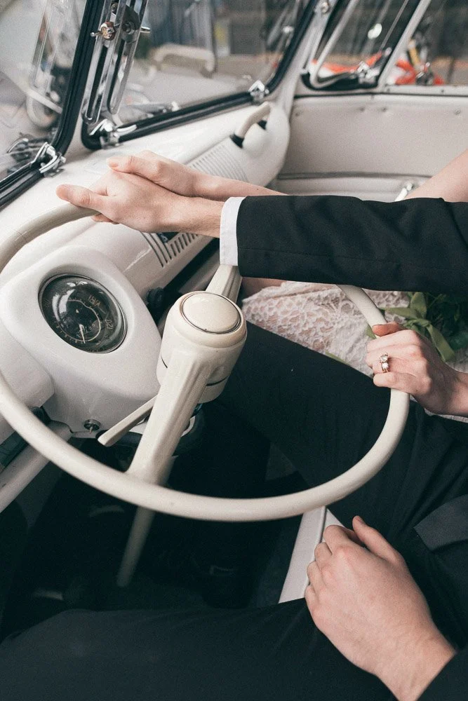 MELBOURNE  EDITORIAL WEDDING PHOTOGRAPHY, BRIDE AND GROOM POSING IN A OLD SCHOOL VW KOMBI VAN, CLOSE UP HOLDING THE CAR WHEEL