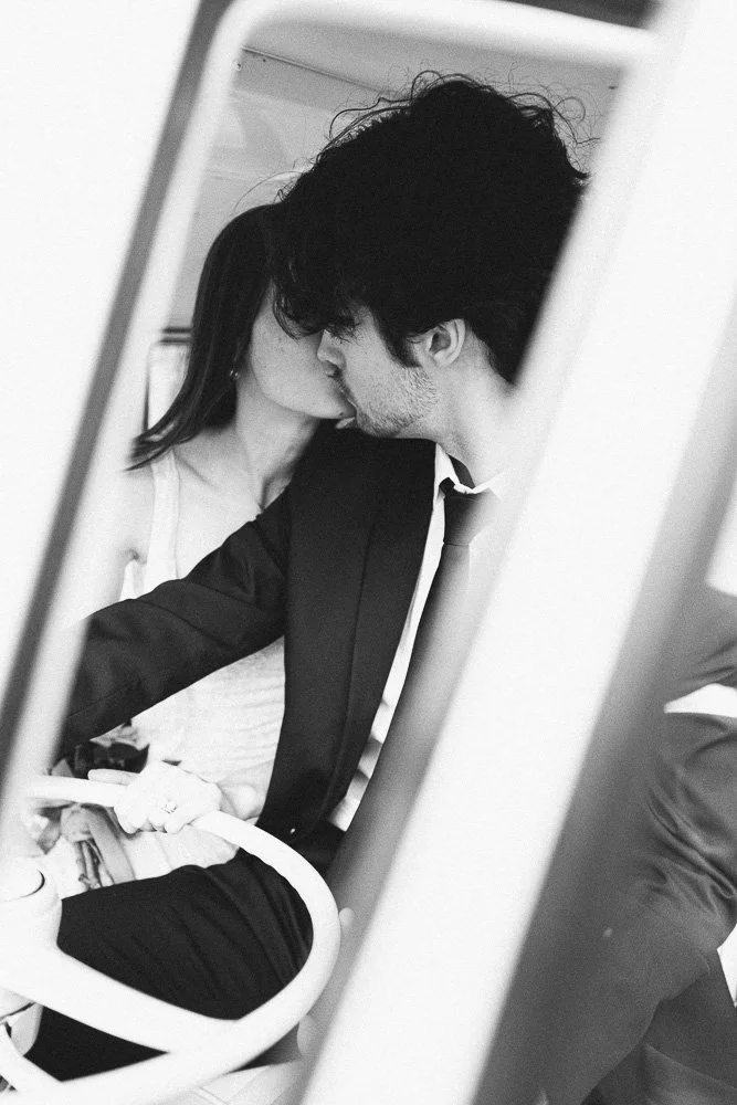 MELBOURNE  EDITORIAL WEDDING PHOTOGRAPHY, BRIDE AND GROOM POSING IN A OLD SCHOOL VW KOMBI VAN, CLOSE UP HOLDING THE CAR WHEEL KISSING