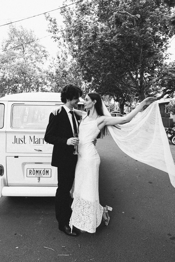 MELBOURNE  EDITORIAL WEDDING PHOTOGRAPHY, BRIDE AND GROOM POSING IN A OLD SCHOOL VW KOMBI VAN, BRIDE LIFTING HER VEIL