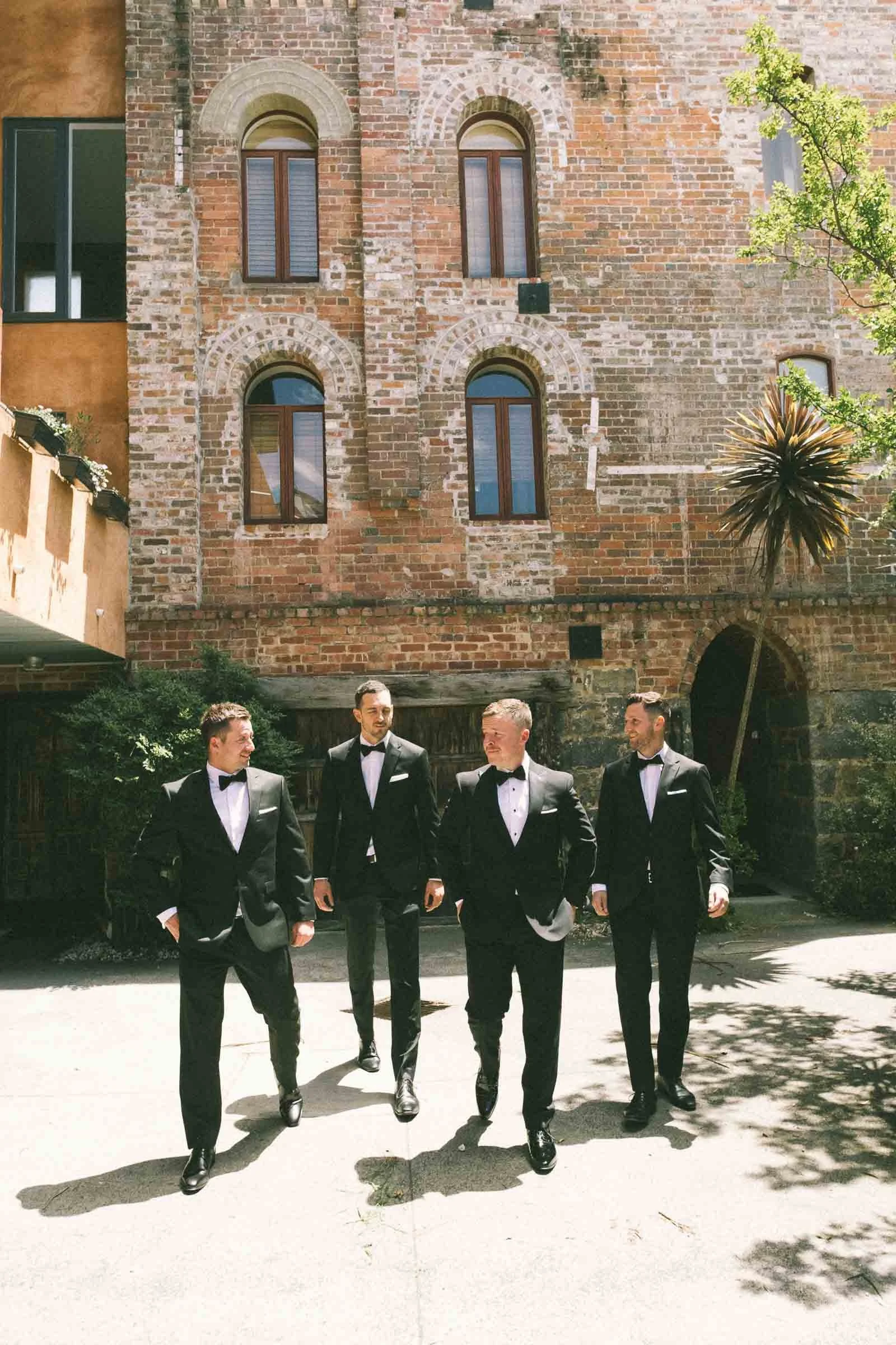 MELBOURNE BOTANICAL GARDEN WEDDING, GROOM GETTING READY, GROOMS PORTRAIT IN A BLACK SUIT ALOONG WITH THE GROOMSMEN