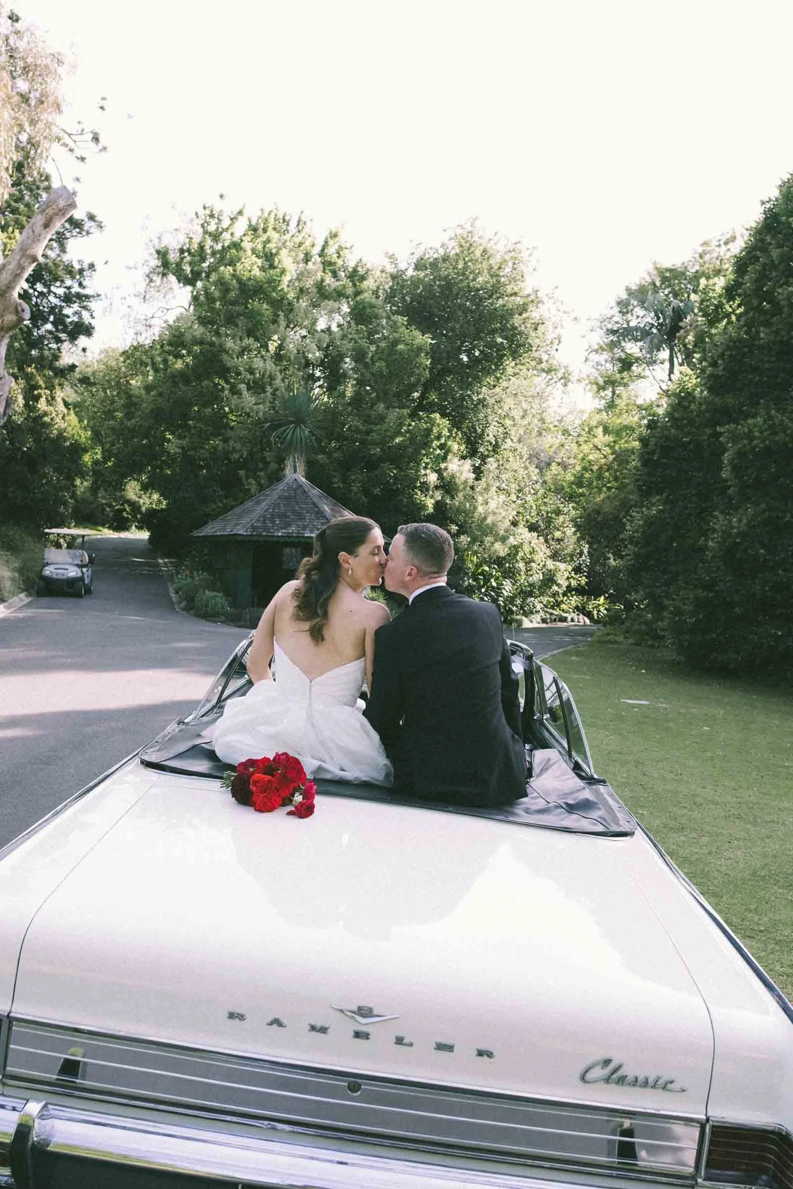 MELBOURNE BOTANICAL GARDEN WEDDING, BRIDE AND GROOM POSING IN A VINTAGE CONVERTIBLE CAR