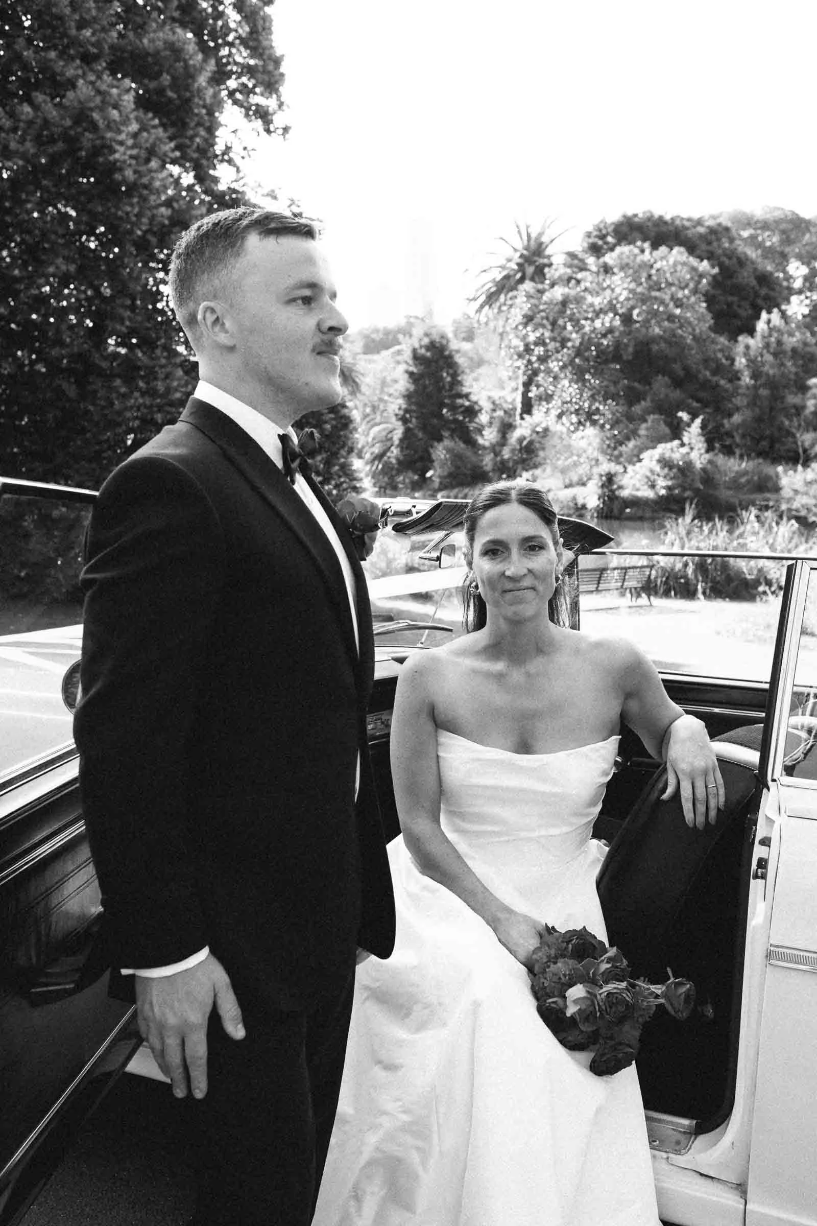 MELBOURNE BOTANICAL GARDEN WEDDING, BRIDE AND GROOM POSING IN A VINTAGE CONVERTIBLE CAR
