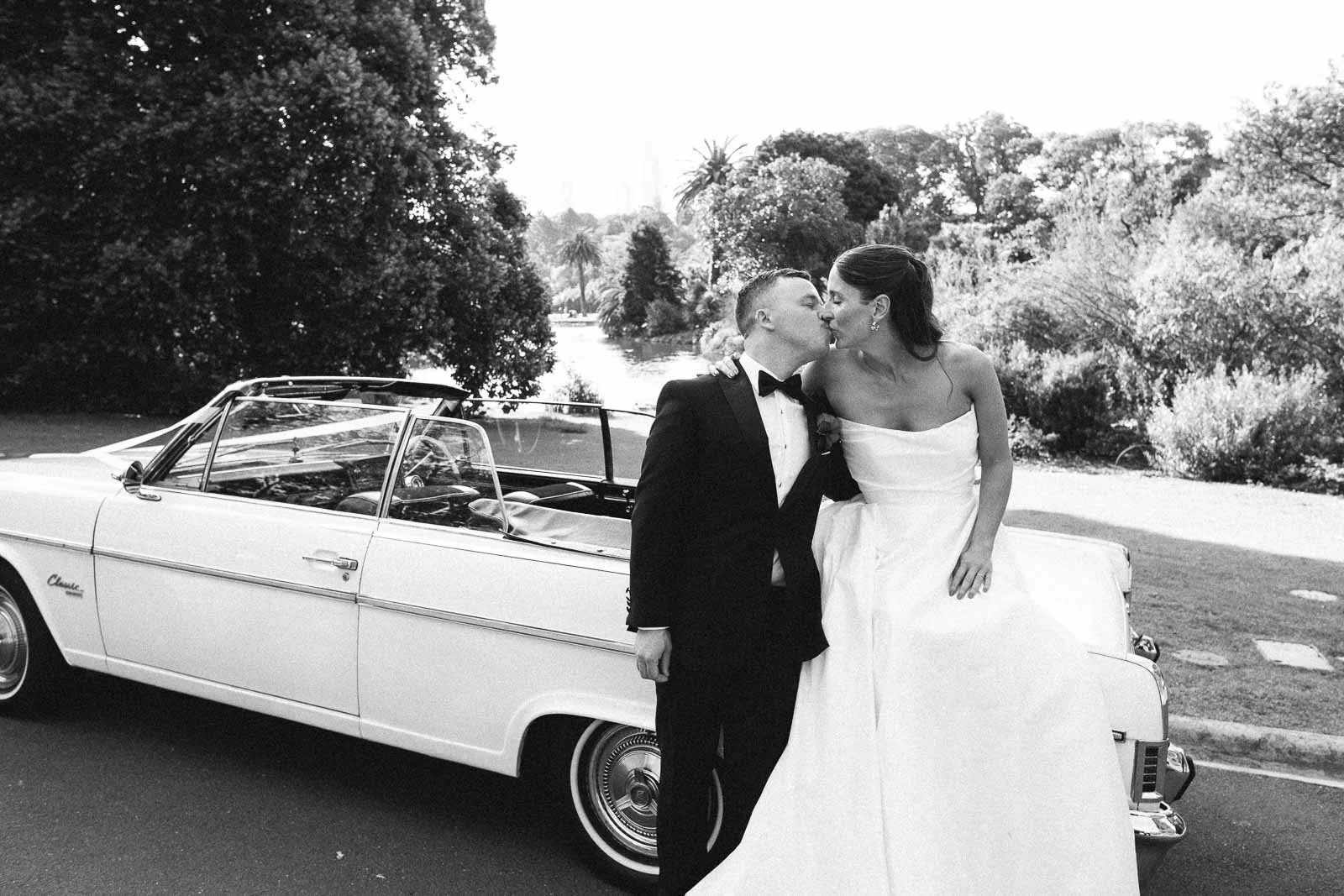 MELBOURNE BOTANICAL GARDEN WEDDING, BRIDE AND GROOM POSING IN A VINTAGE CONVERTIBLE CAR