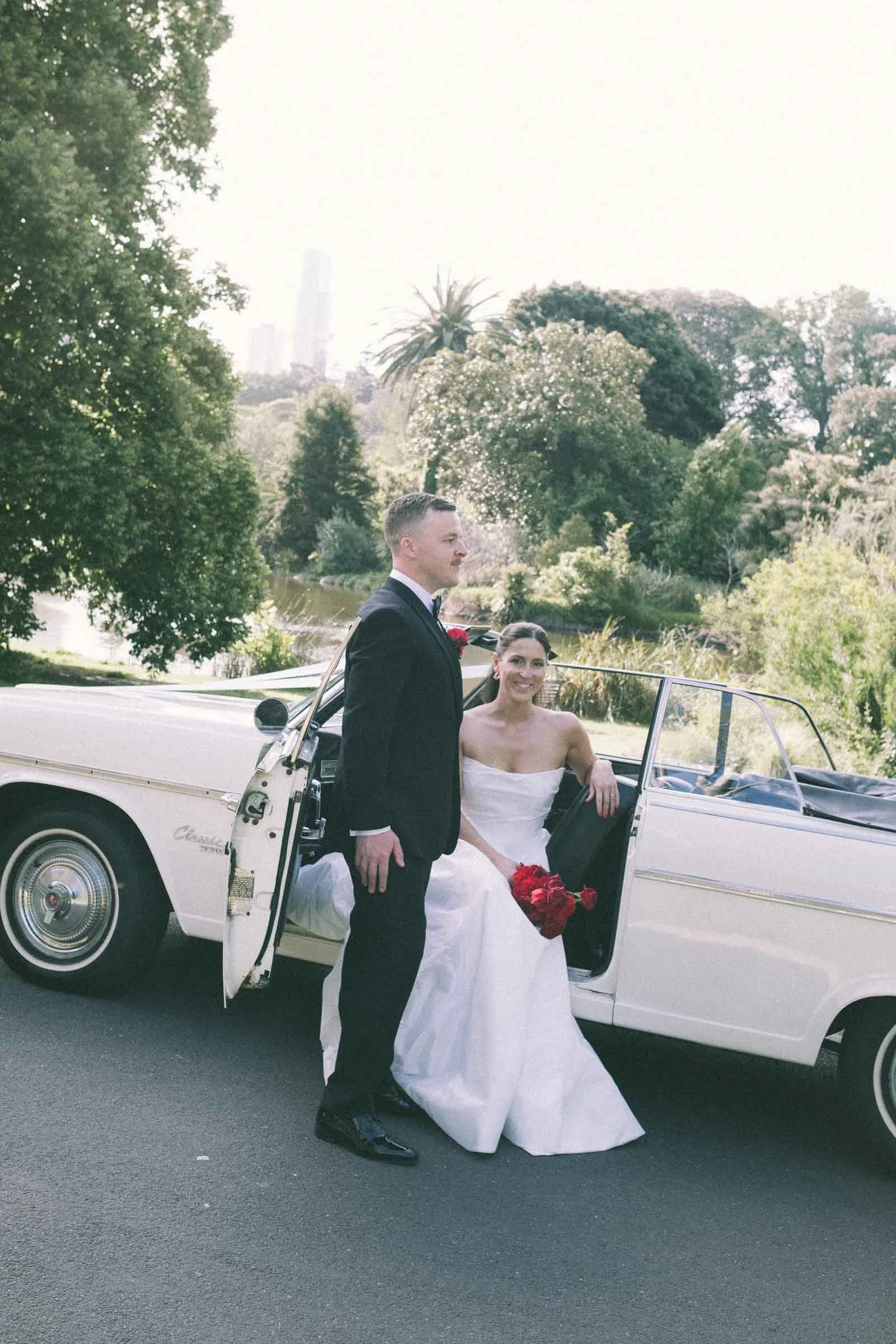 MELBOURNE BOTANICAL GARDEN WEDDING, BRIDE AND GROOM POSING IN A VINTAGE CONVERTIBLE CAR