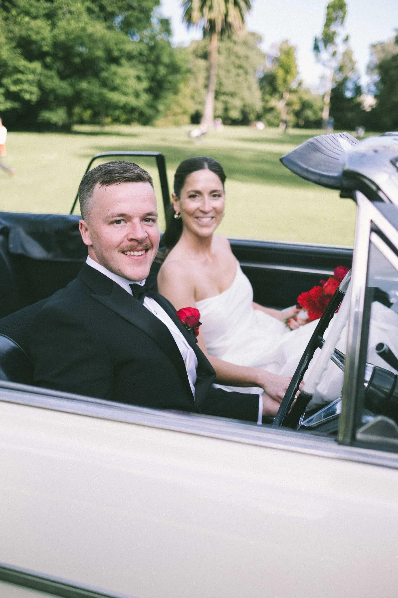 MELBOURNE BOTANICAL GARDEN WEDDING, BRIDE AND GROOM POSING IN A VINTAGE CONVERTIBLE CAR