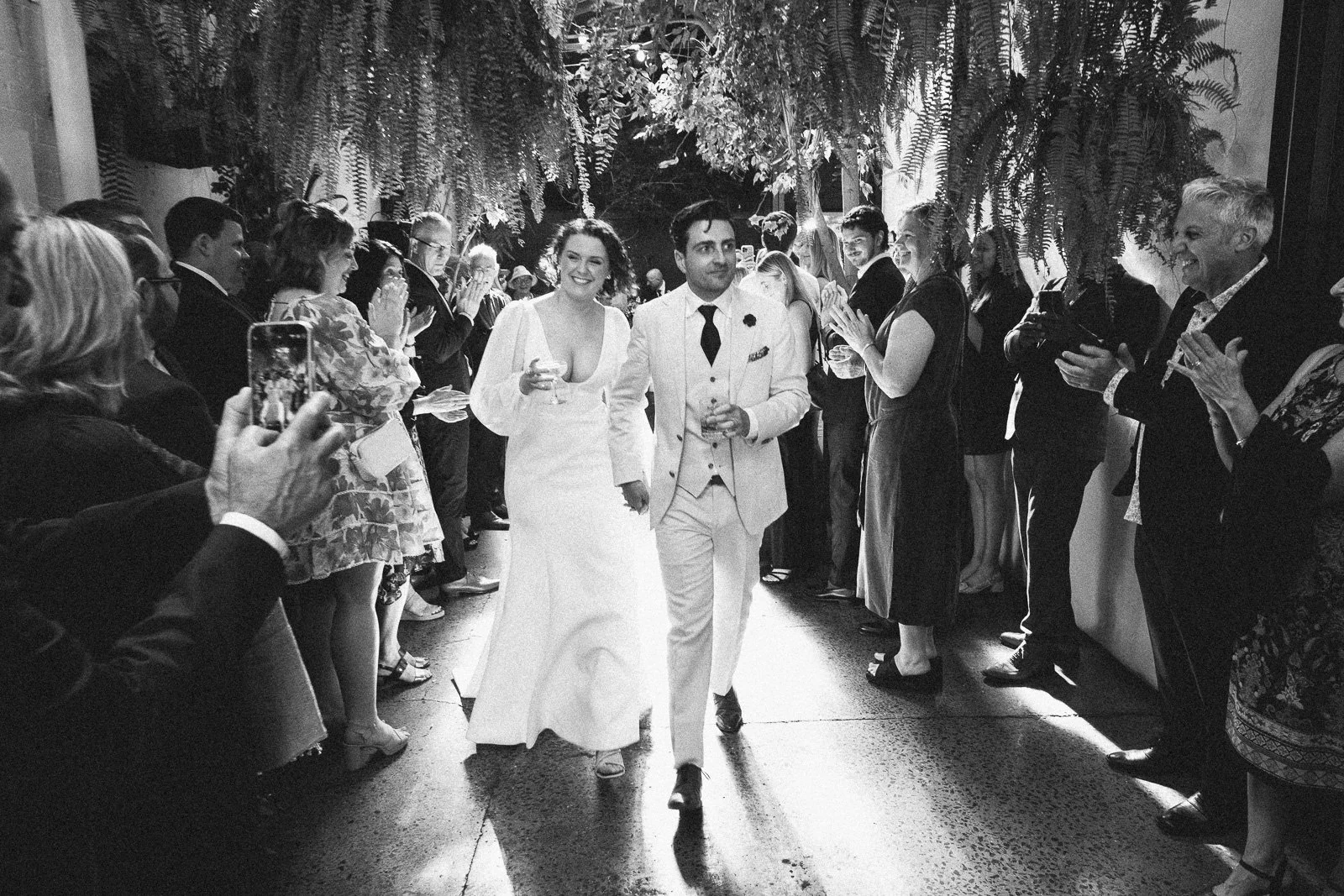 RUPERT ON RUPERT INDUSTRIAL WEDDING, COUPLE WALKING DOWN THE ISLE AFTER THE WEDDING BEING CHEERED BY ALL THEIR GUESTS