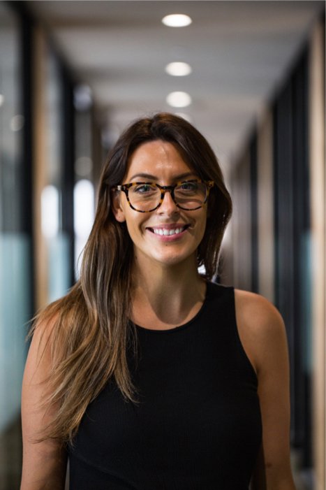 Smiling woman with glasses in hallway