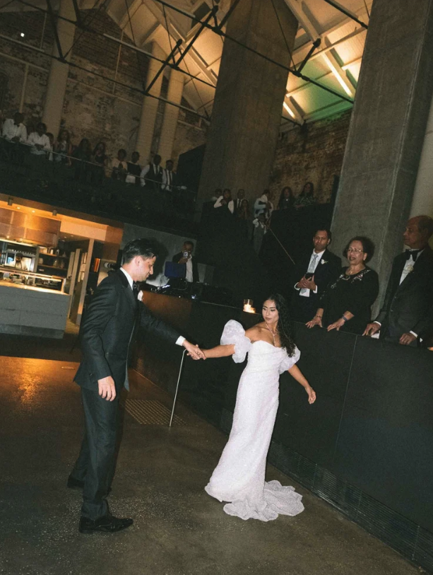Wedding couple dancing at the higher ground melbourne industrial wedding venue in front of their guests