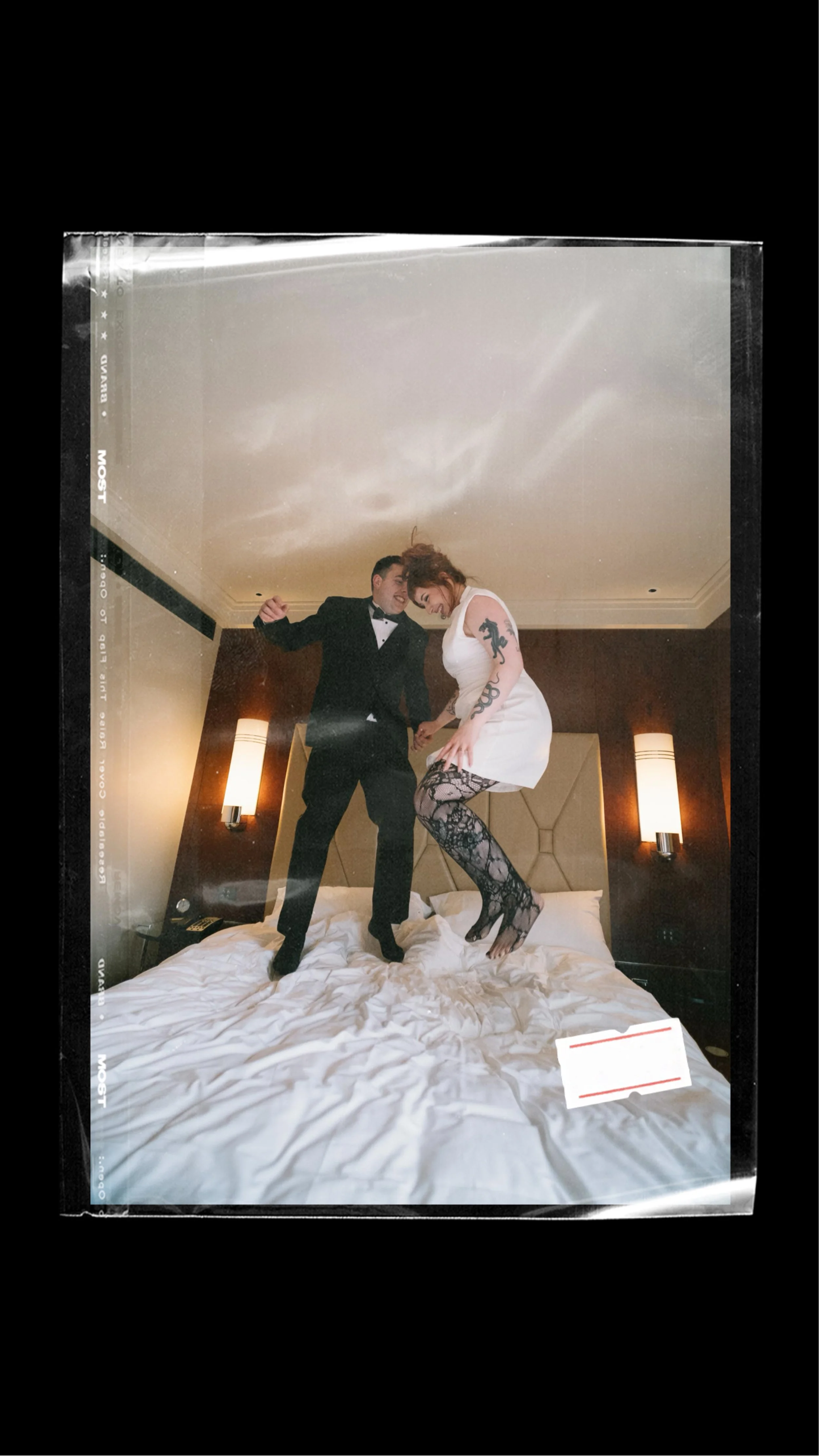 IMAGE OF A COUPLE JUMPING ON THE BED OF THEIR HOTEL ROOM AFTER THE ELOPEMENT CEREMONY