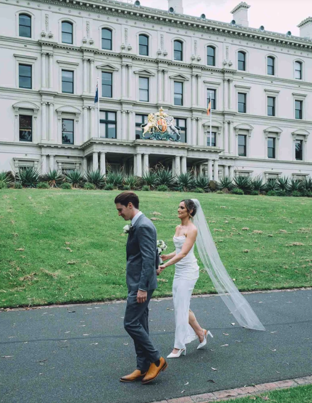 A Couple walking through treasury gardens after their wedding at the Old Treasury Building