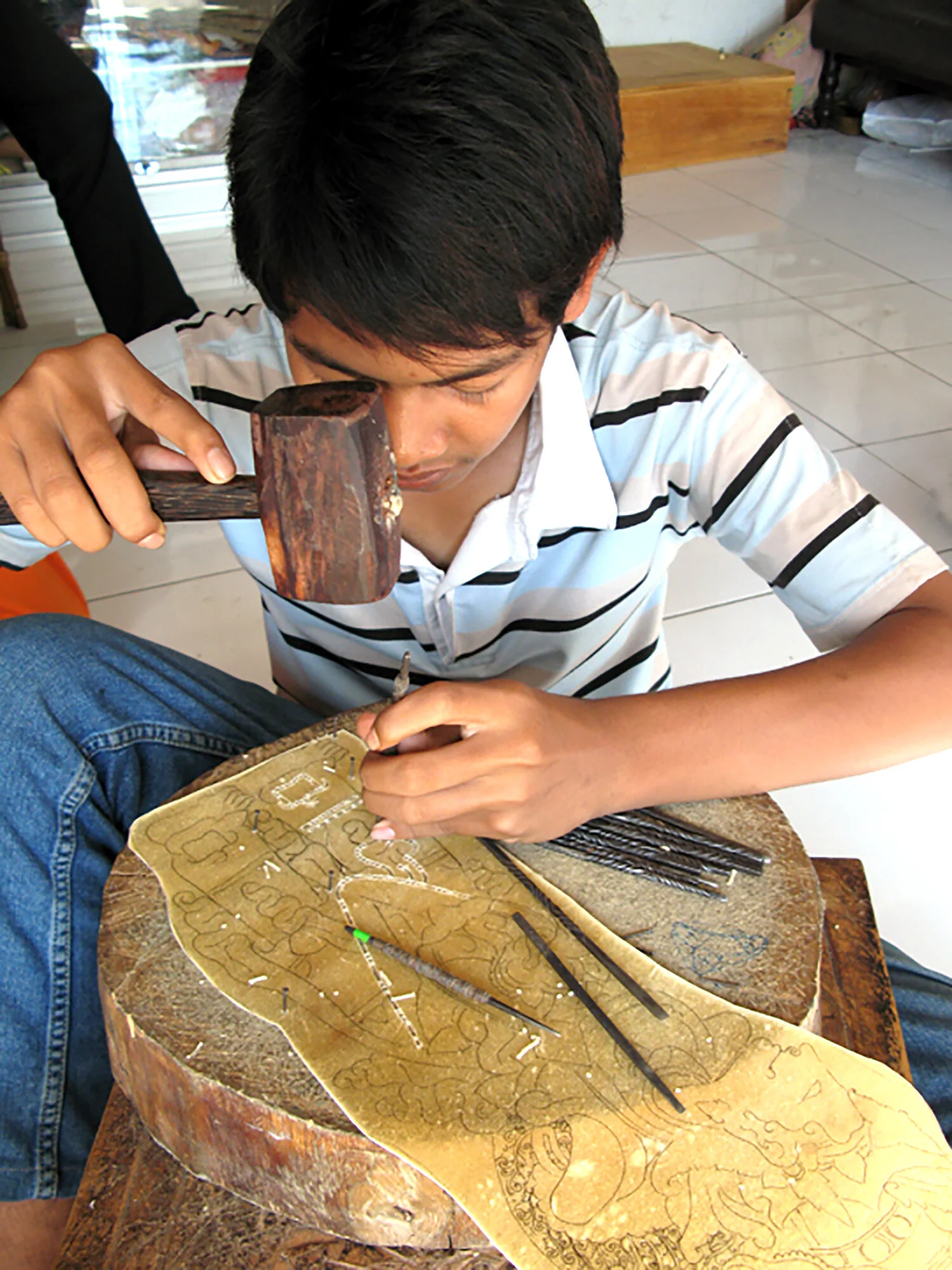 Cow hide is punched out into patterns to make the puppets