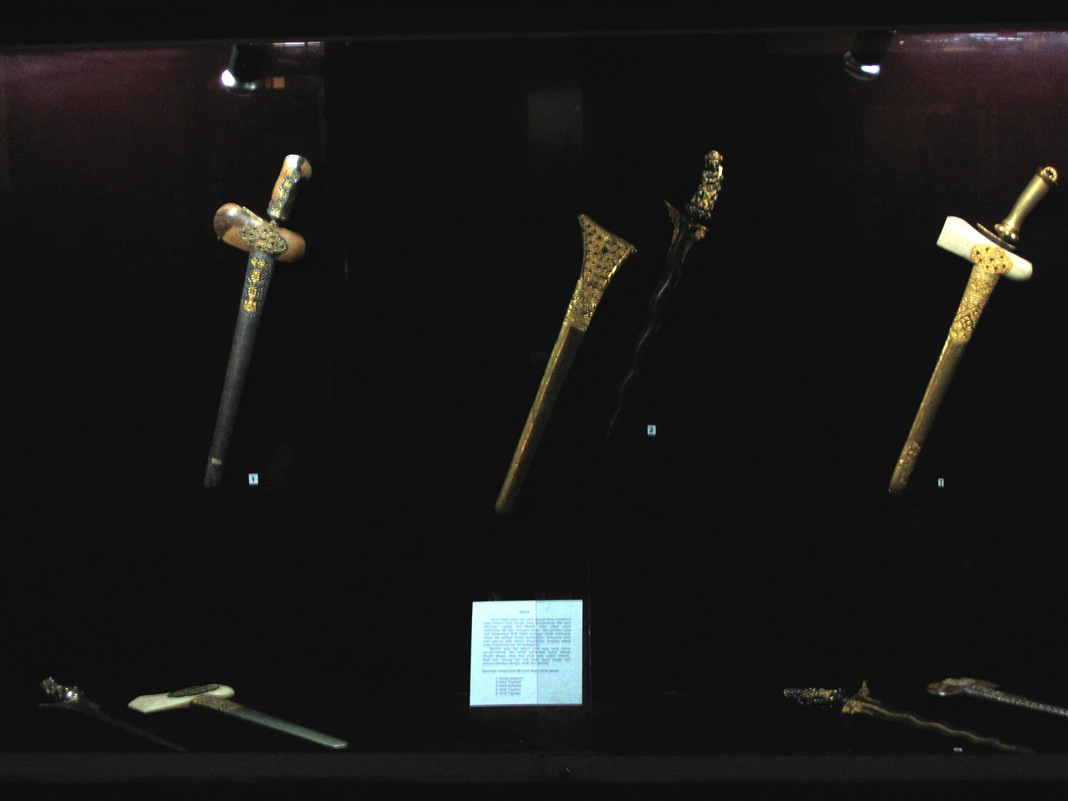 Exhibit of Kris knives behind glass barrier