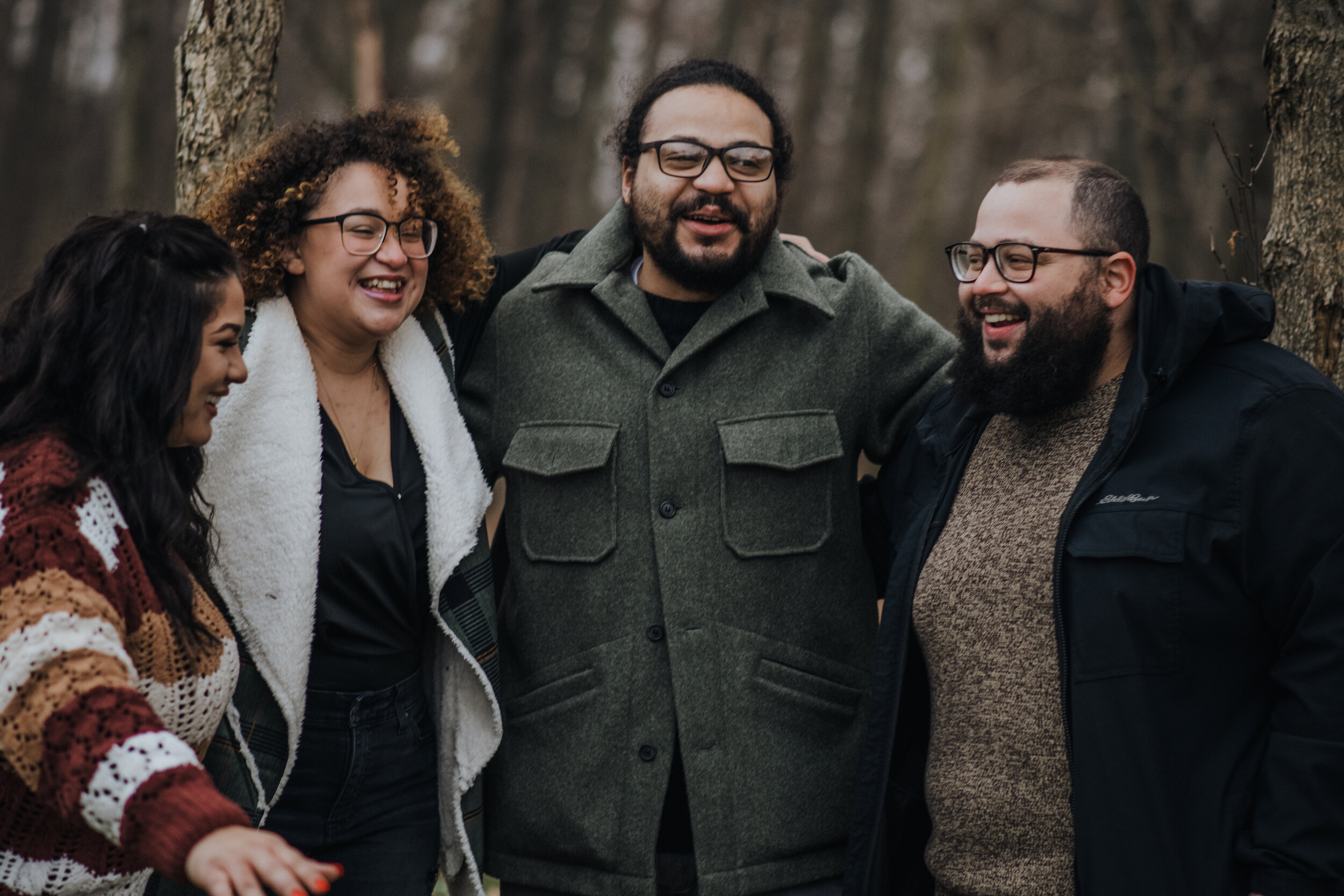Candid photo of grown-up brothers and sisters laughing together during a family photography session by Forever Ago Photography. Capturing authentic sibling connections and joyful moments in Flint Michigan