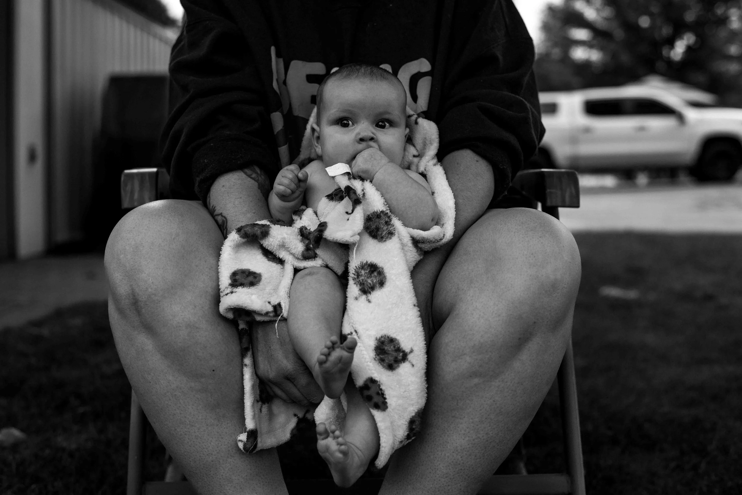 Candid photo of a mom casually holding her baby during a family photography session by Forever Ago Photography. Capturing authentic, tender moments of motherhood in a natural setting in Huron Michigan