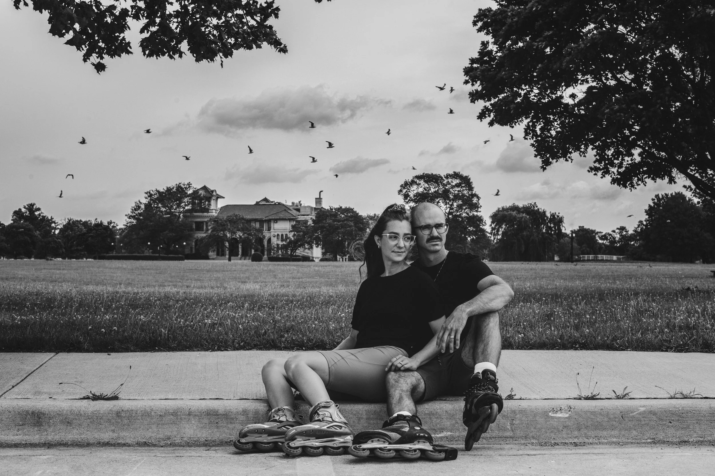 Candid image of an engaged couple enjoying a rollerblading session, part of a lifestyle engagement shoot by Forever Ago Photography at Belle Isle Detroit Michigan