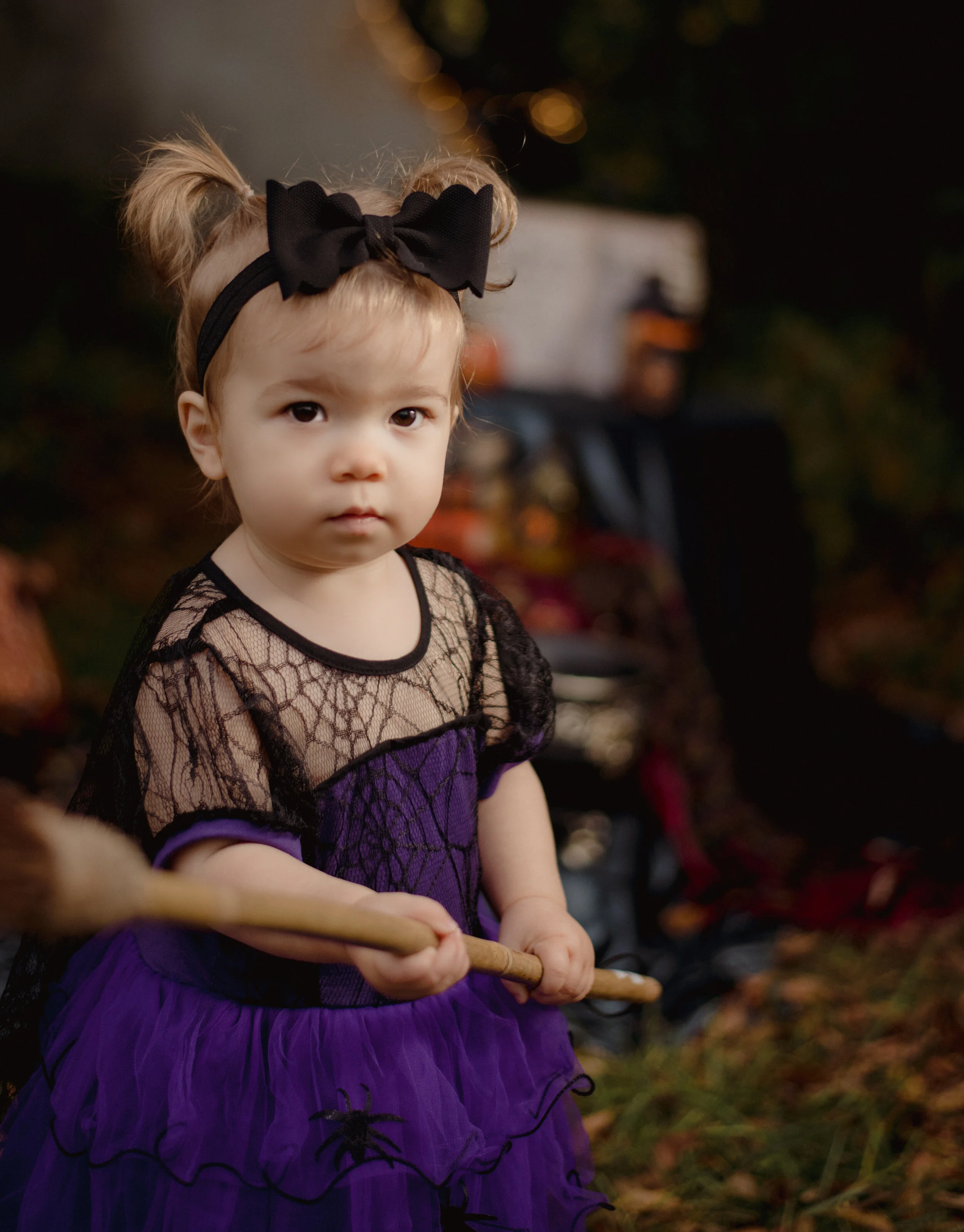 Candid photo of a toddler girl exploring a Halloween setup during a family photography session by Forever Ago Photography. Capturing the joy and wonder of childhood in a festive, seasonal setting in Carleton Michigan